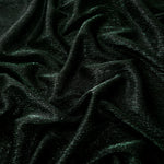 Draped Deep Emerald Sheer Glitter Stretch Tulle Fabric showing scattered sparkle across fluid folds for eveningwear and stage looks