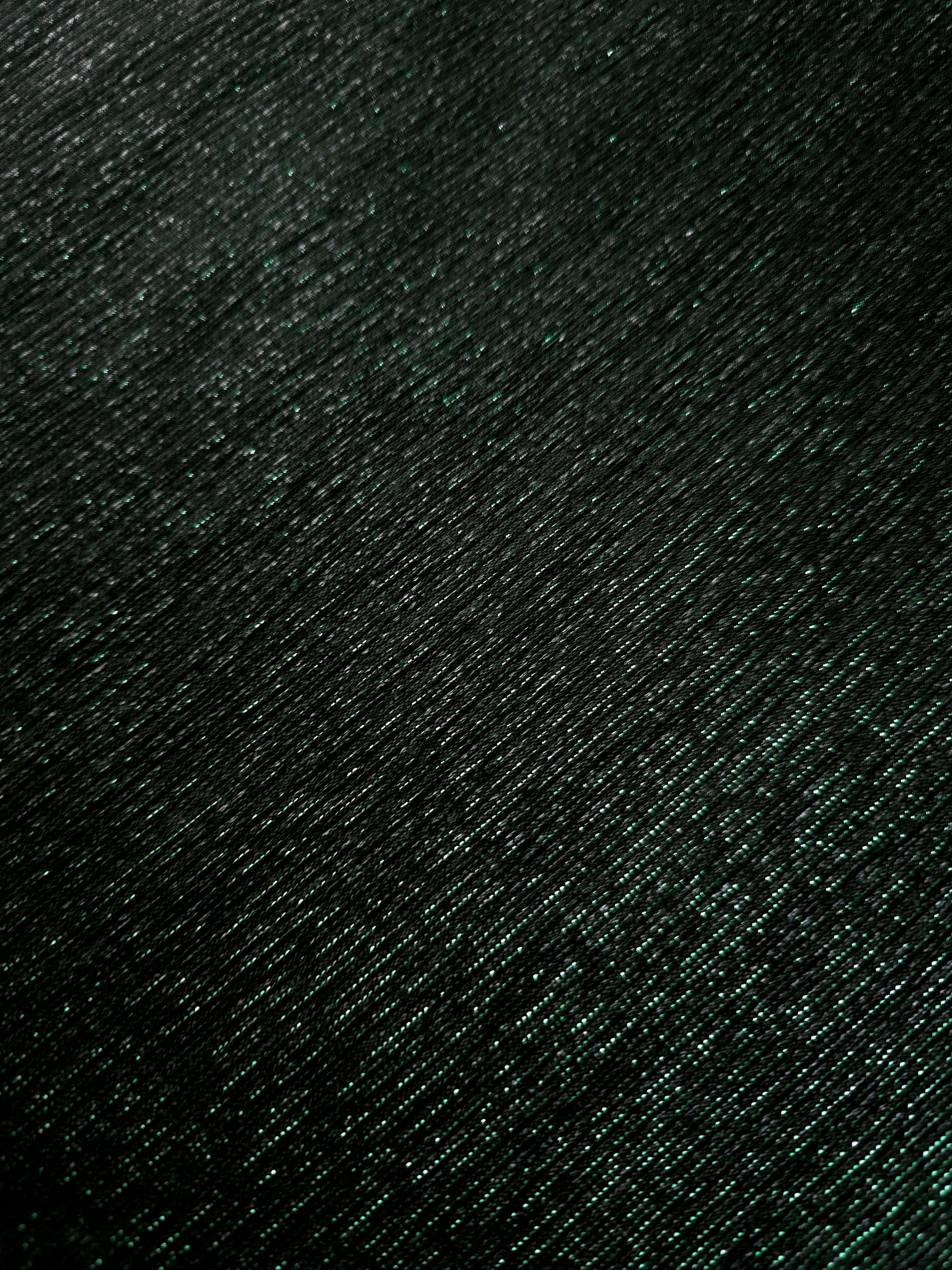 Surface detail of Deep Emerald Sheer Glitter Stretch Tulle Fabric showing glitter coverage across the fine sheer tulle base