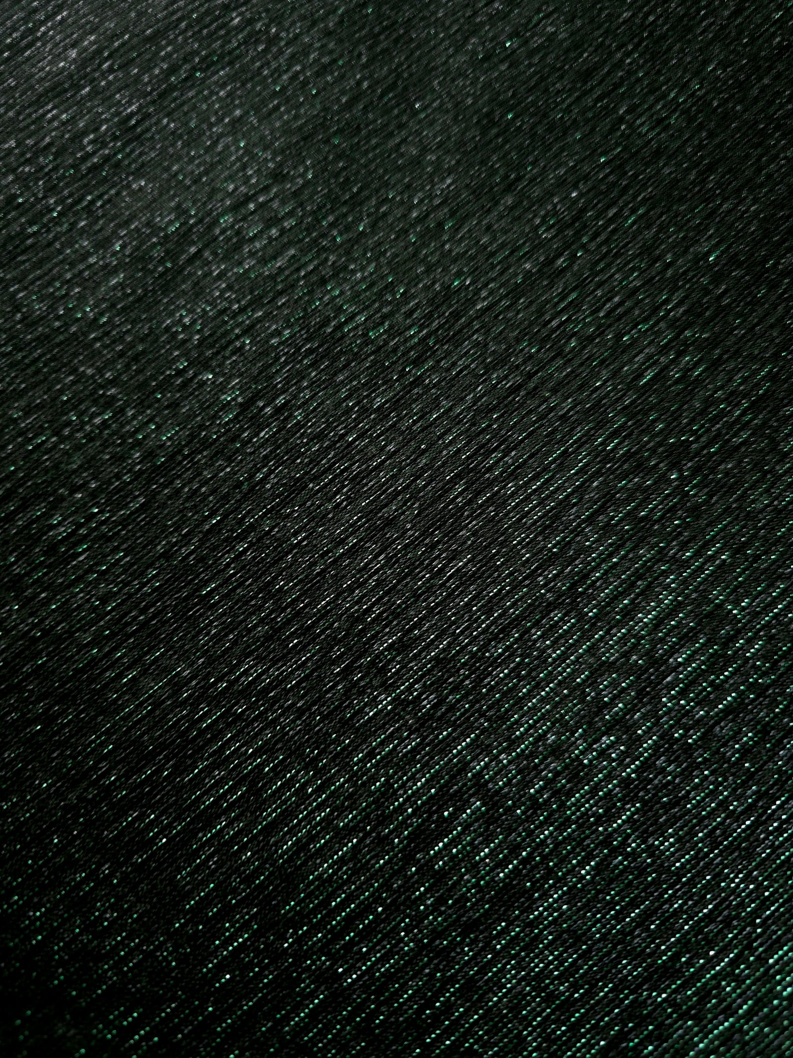 Surface detail of Deep Emerald Sheer Glitter Stretch Tulle Fabric showing glitter coverage across the fine sheer tulle base