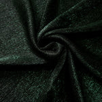 Swirl-draped Deep Emerald Sheer Glitter Stretch Tulle Fabric capturing reflective sparkle and fluid movement through flexible folds
