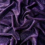 Draped Deep Violet Sheer Glitter Stretch Tulle Fabric showing scattered sparkle across fluid folds for eveningwear and stage looks