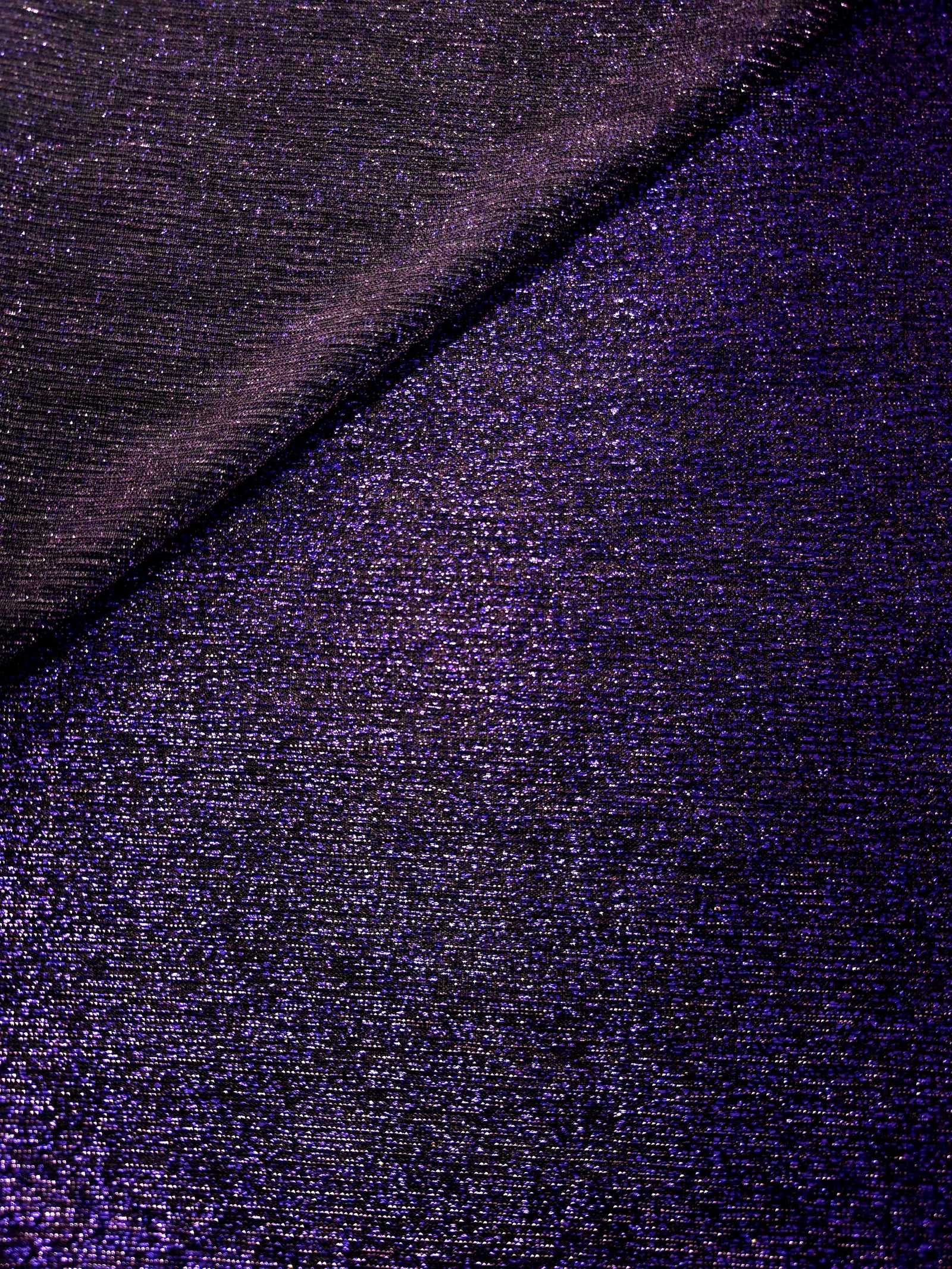 Front and back of Deep Violet Sheer Glitter Stretch Tulle Fabric showing transparent knit construction and flexible 4-way stretch