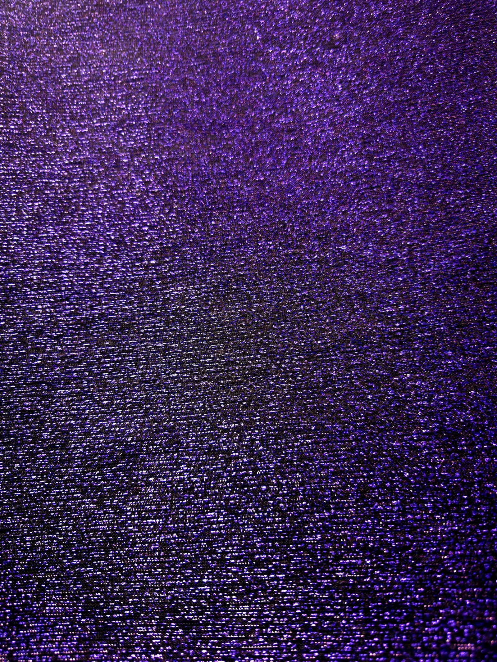Surface detail of Deep Violet Sheer Glitter Stretch Tulle Fabric showing glitter coverage across the fine sheer tulle base