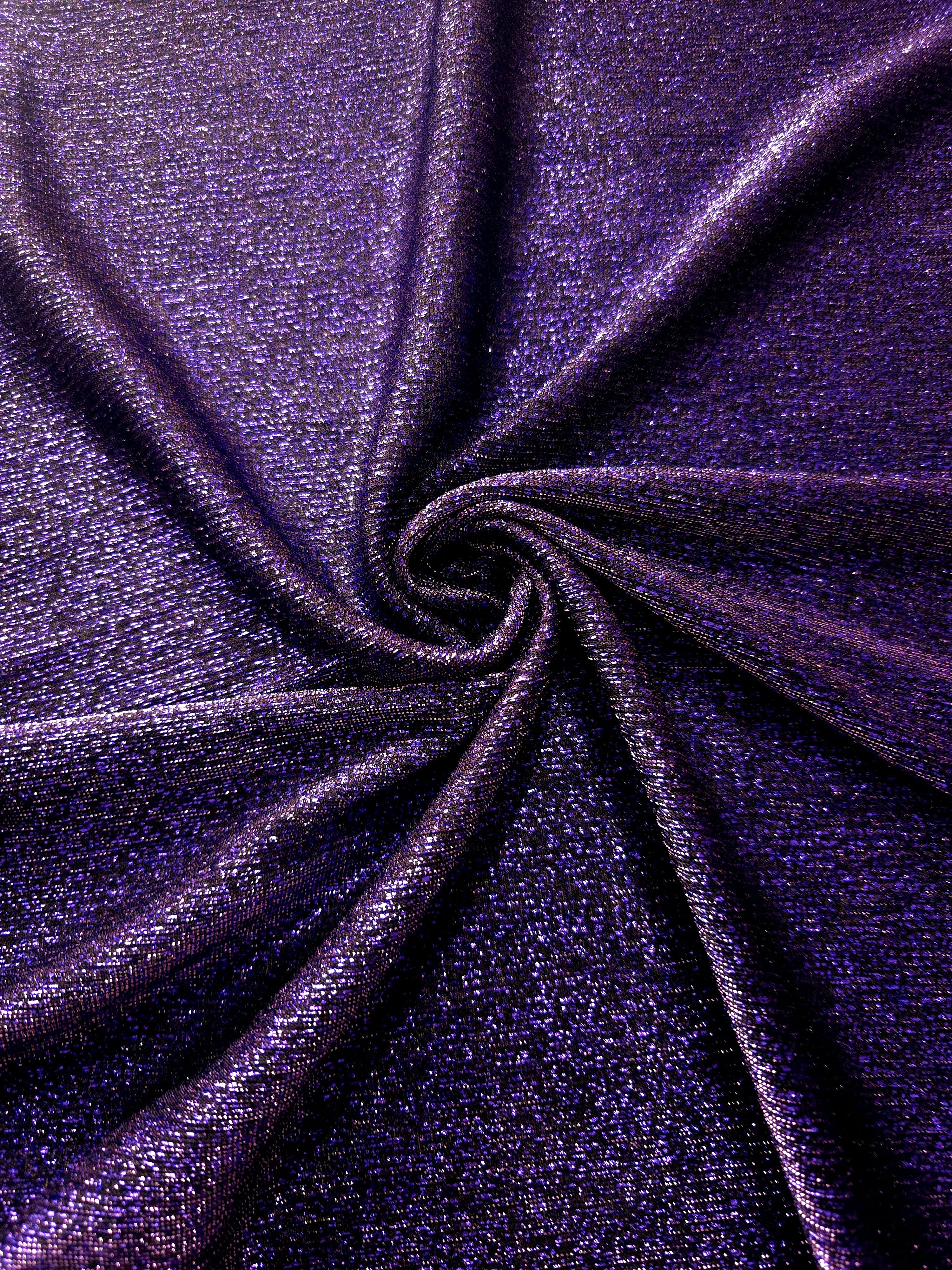 Swirl-draped Deep Violet Sheer Glitter Stretch Tulle Fabric capturing reflective sparkle and fluid movement through flexible folds