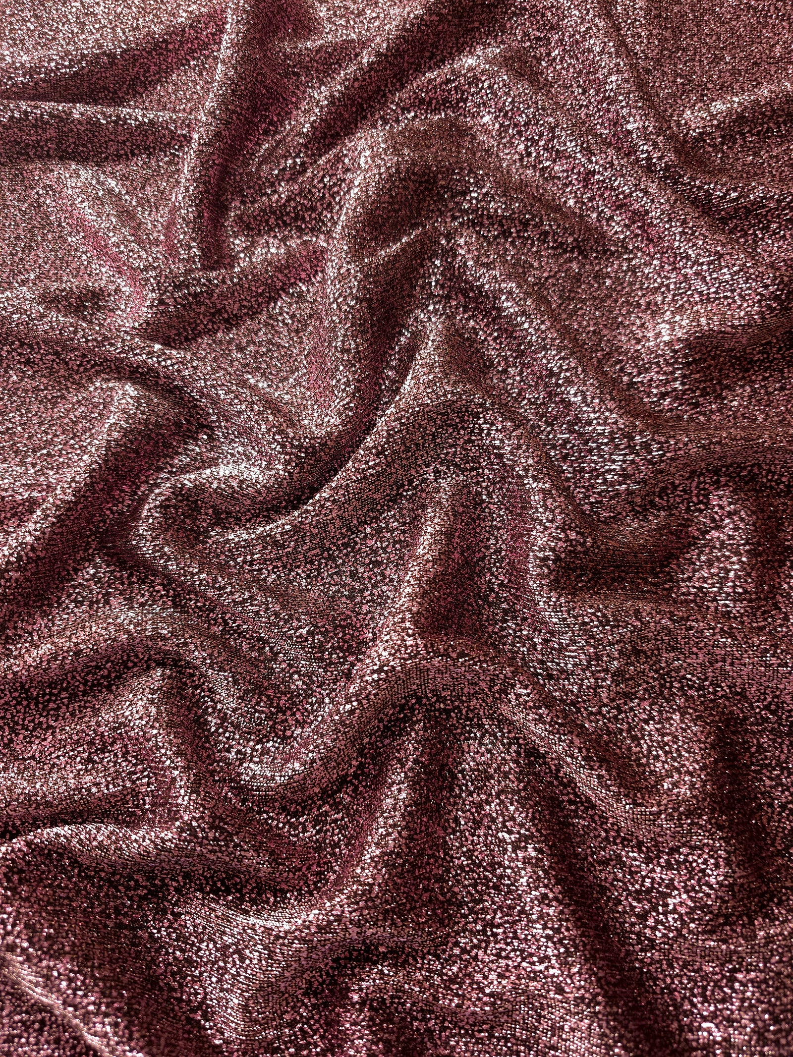 Draped Dusty Rose Sheer Glitter Stretch Tulle Fabric showing scattered sparkle across fluid folds for eveningwear and stage looks