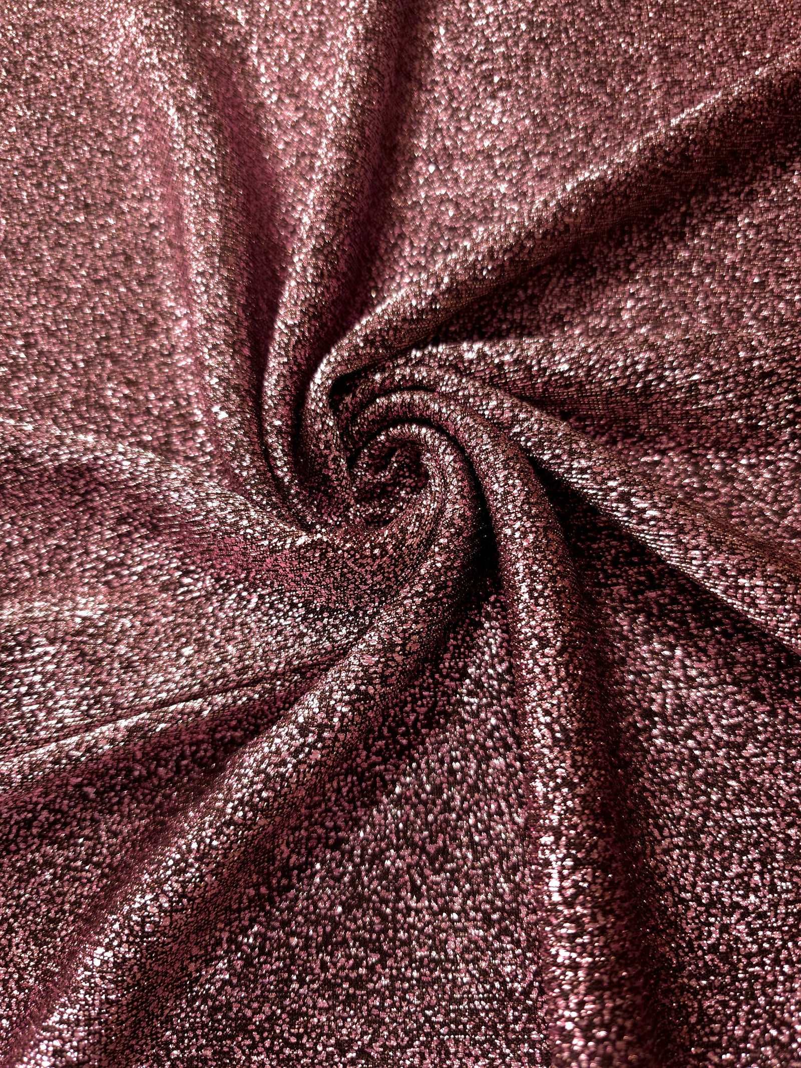 Swirl-draped Dusty Rose Sheer Glitter Stretch Tulle Fabric capturing reflective sparkle and fluid movement through flexible folds