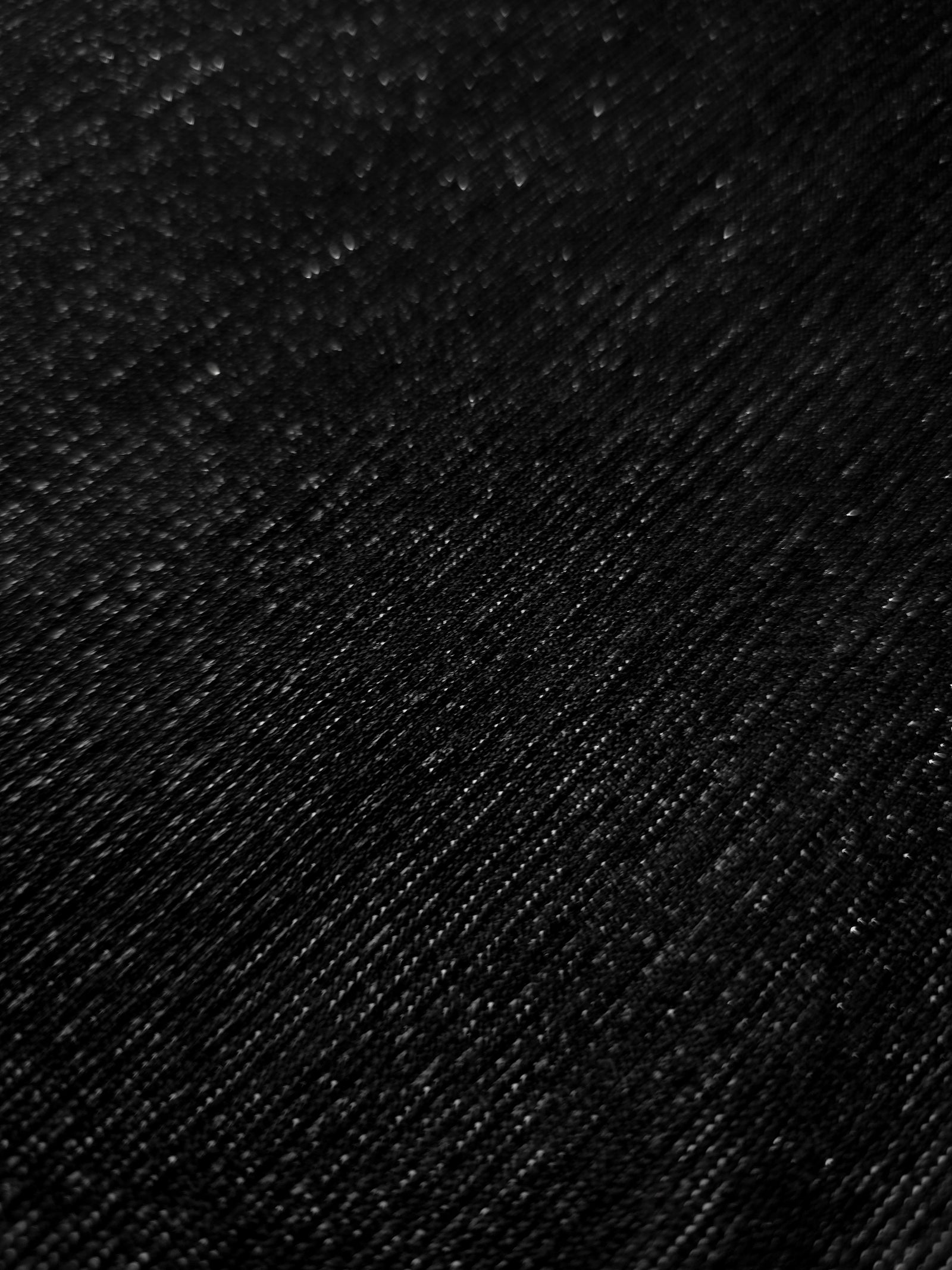 Close-up of Jet Black Sheer Glitter Stretch Tulle Fabric highlighting all-over glitter, fine mesh texture and airy transparency