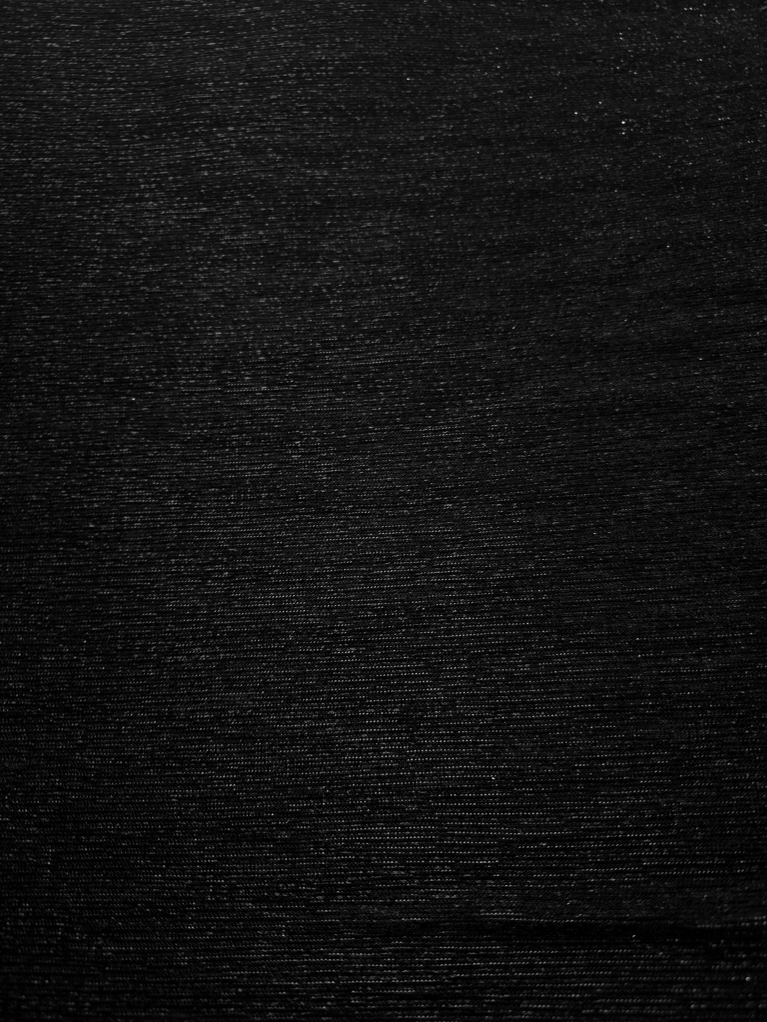 Surface detail of Jet Black Sheer Glitter Stretch Tulle Fabric showing glitter coverage across the fine sheer tulle base