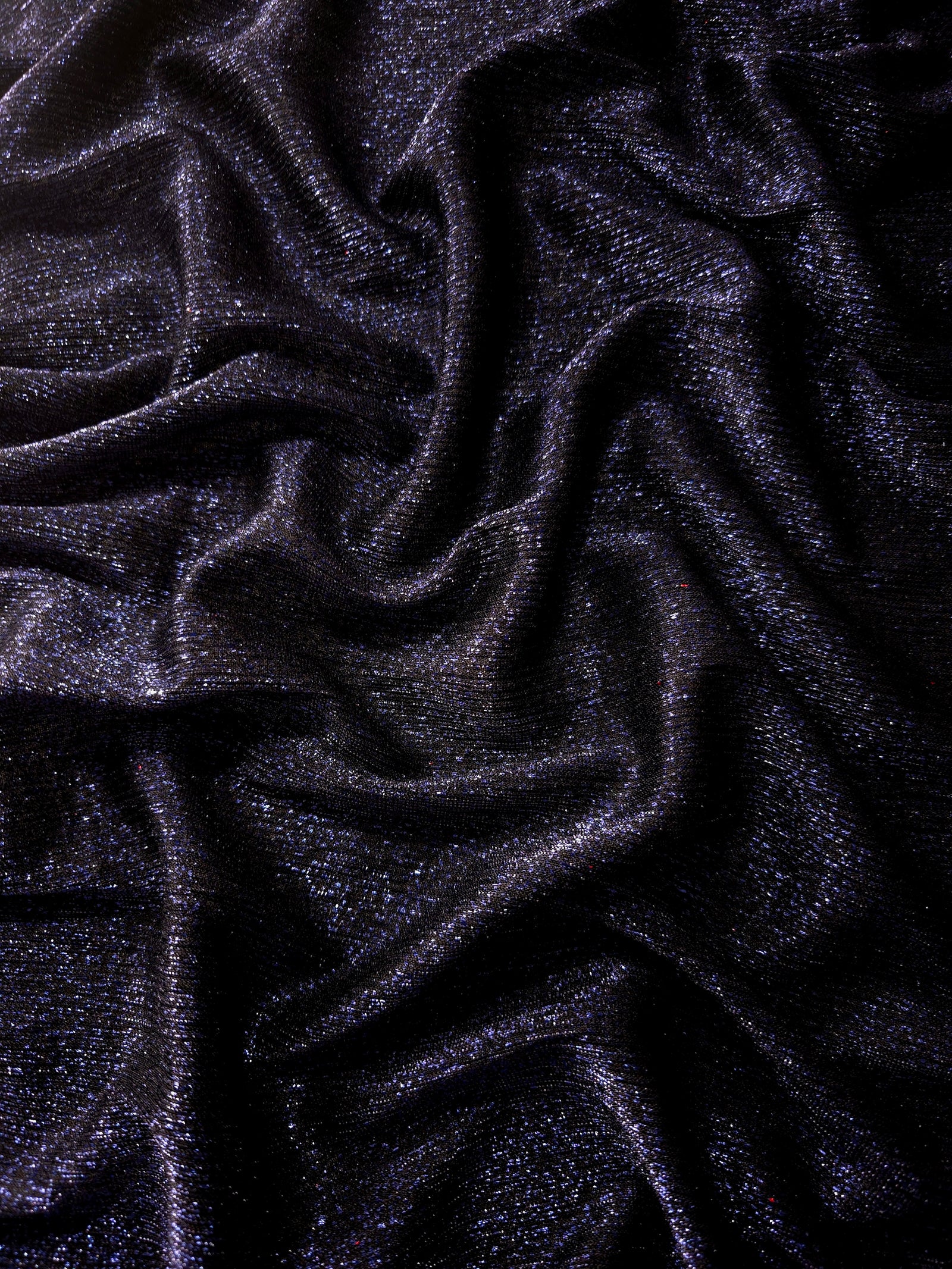 Draped Midnight Navy Sheer Glitter Stretch Tulle Fabric showing scattered sparkle across fluid folds for eveningwear and stage looks