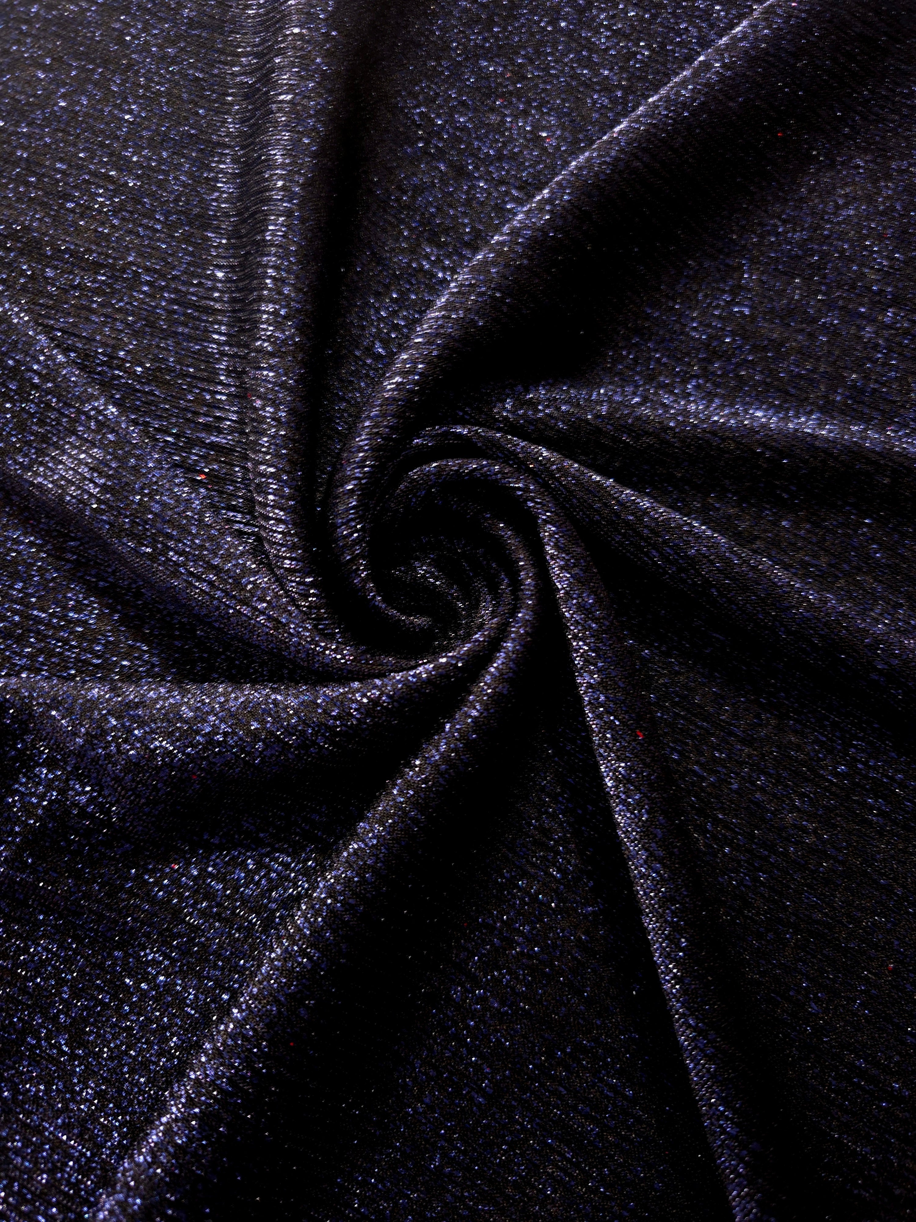 Swirl-draped Midnight Navy Sheer Glitter Stretch Tulle Fabric capturing reflective sparkle and fluid movement through flexible folds