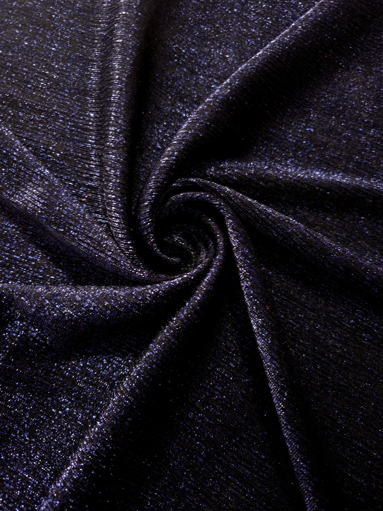 Swirl-draped Midnight Navy Sheer Glitter Stretch Tulle Fabric capturing reflective sparkle and fluid movement through flexible folds