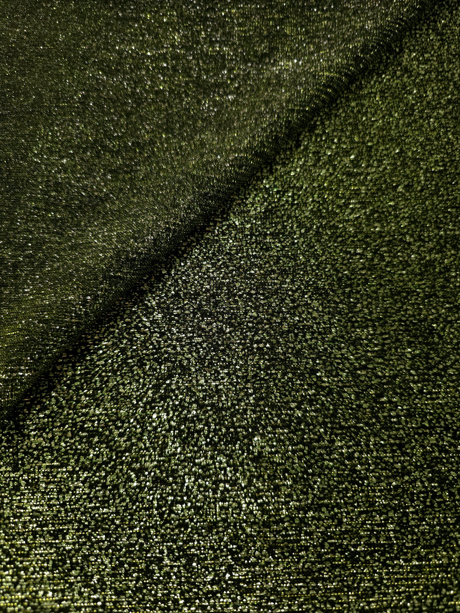 Draped Olive Green Sheer Glitter Stretch Tulle Fabric showing scattered sparkle across fluid folds for eveningwear and stage looks