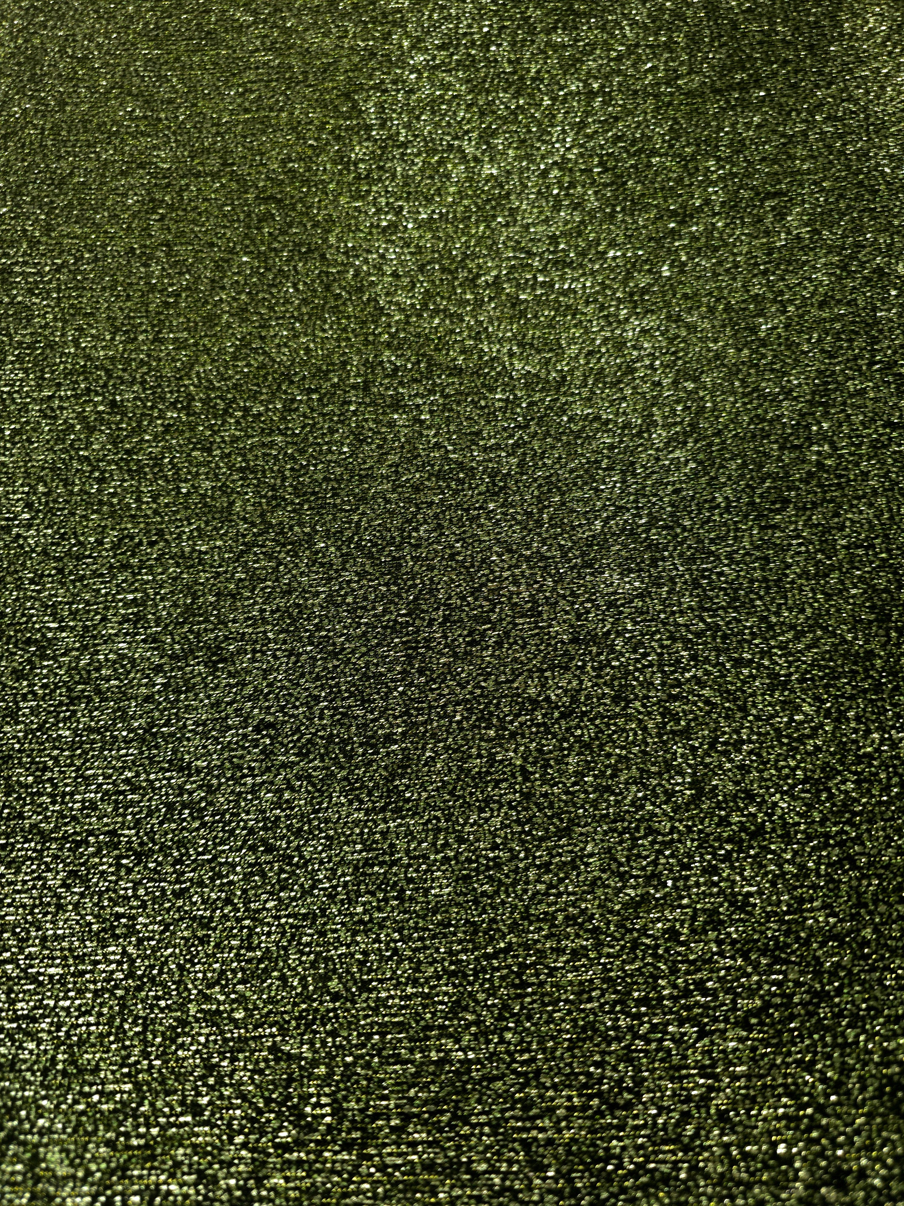 Surface detail of Olive Green Sheer Glitter Stretch Tulle Fabric showing glitter coverage across the fine sheer tulle base