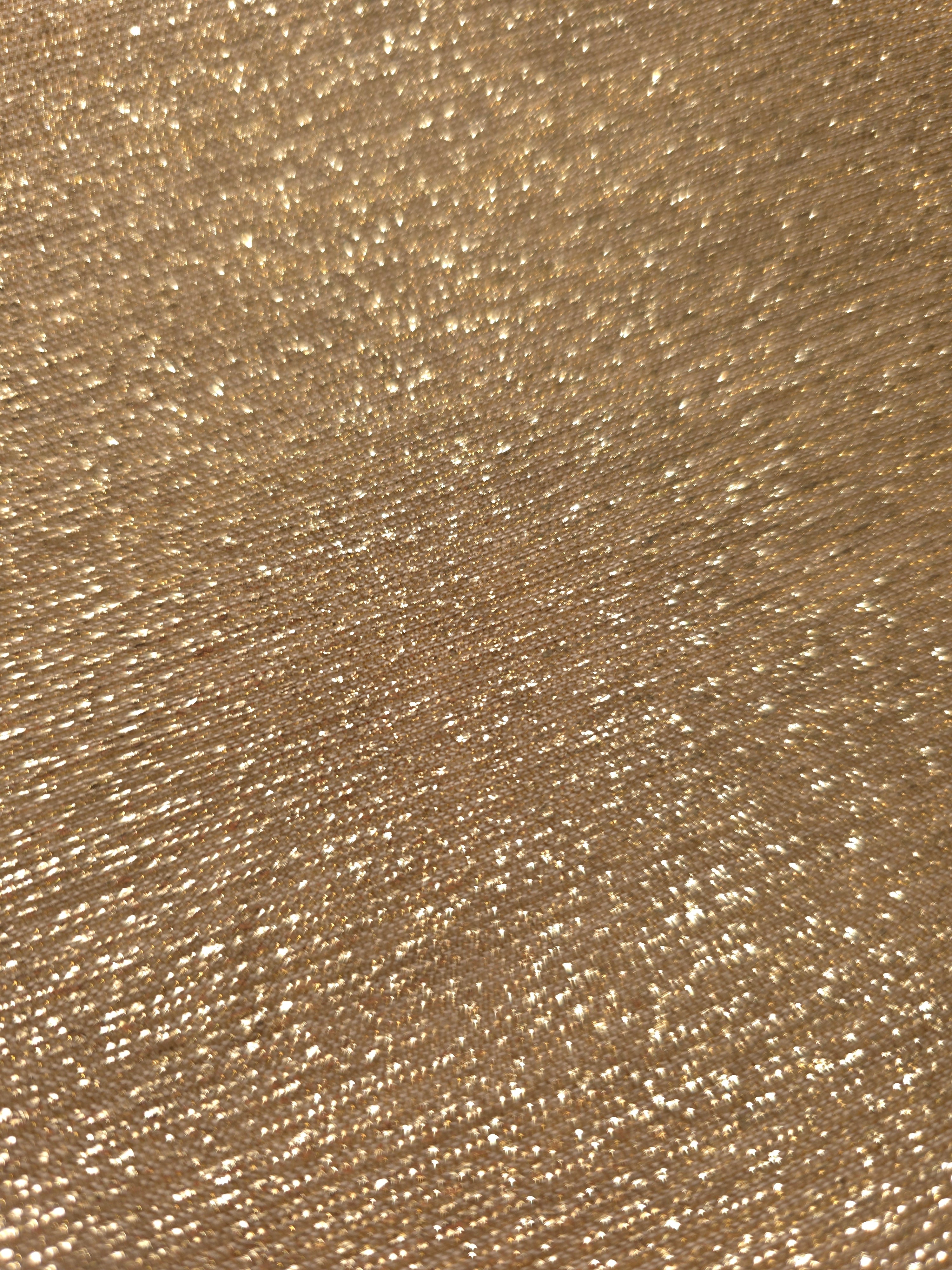 Close-up of Pale Gold Sheer Glitter Stretch Tulle Fabric highlighting all-over glitter, fine mesh texture and airy transparency