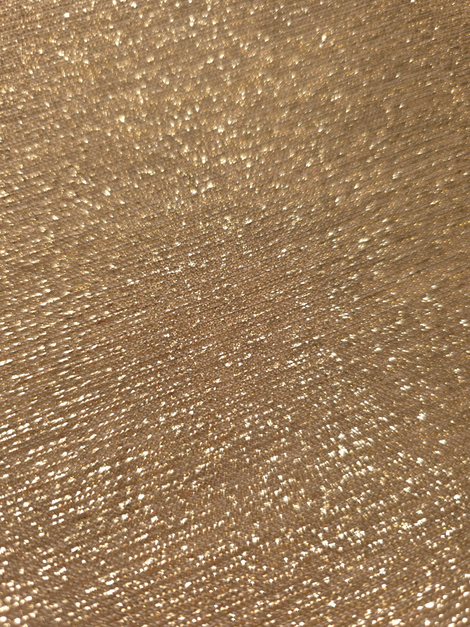 Close-up of Pale Gold Sheer Glitter Stretch Tulle Fabric highlighting all-over glitter, fine mesh texture and airy transparency