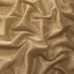 Draped Pale Gold Sheer Glitter Stretch Tulle Fabric showing scattered sparkle across fluid folds for eveningwear and stage looks