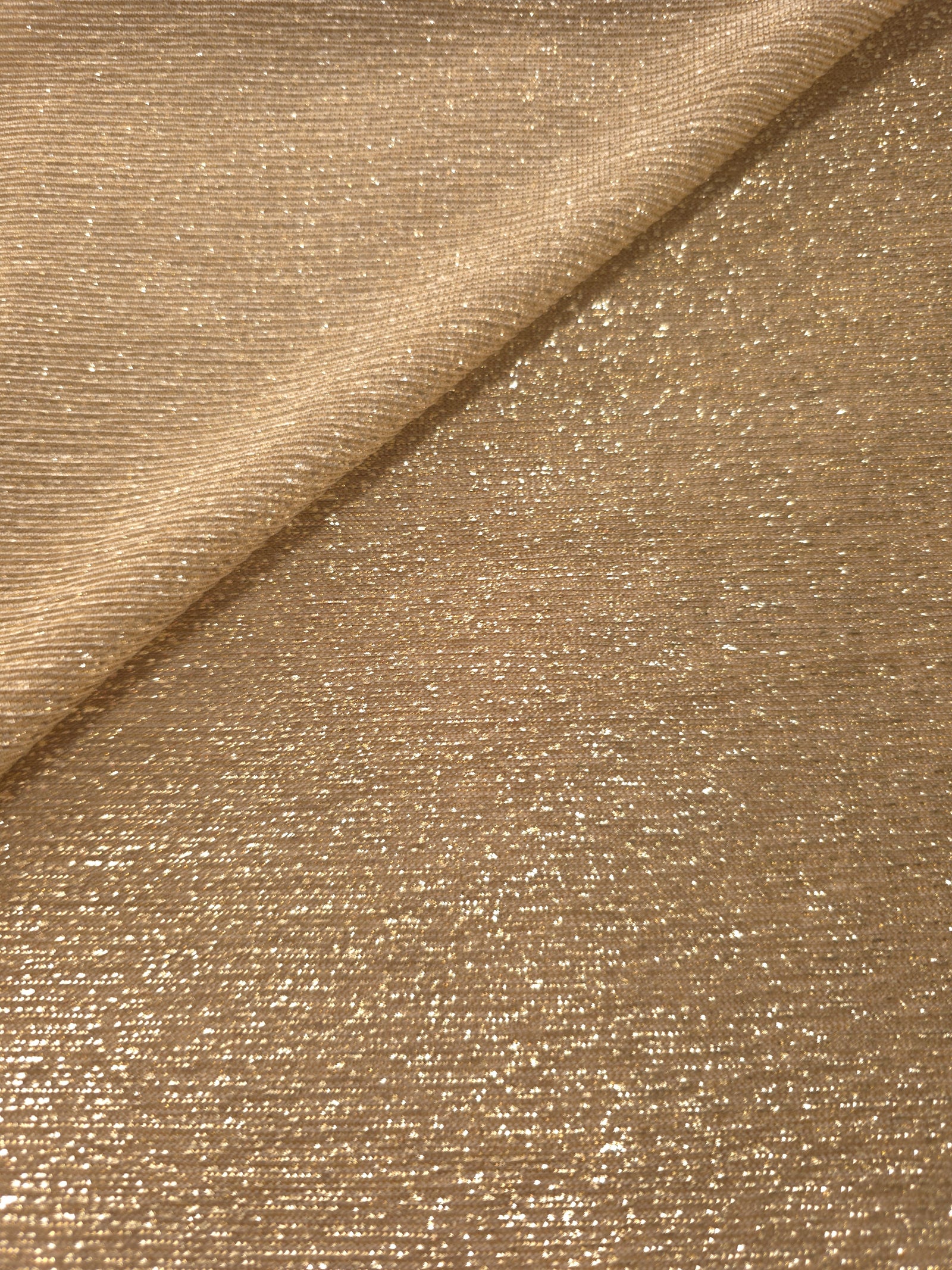 Front and back of Pale Gold Sheer Glitter Stretch Tulle Fabric showing transparent knit construction and flexible 4-way stretch