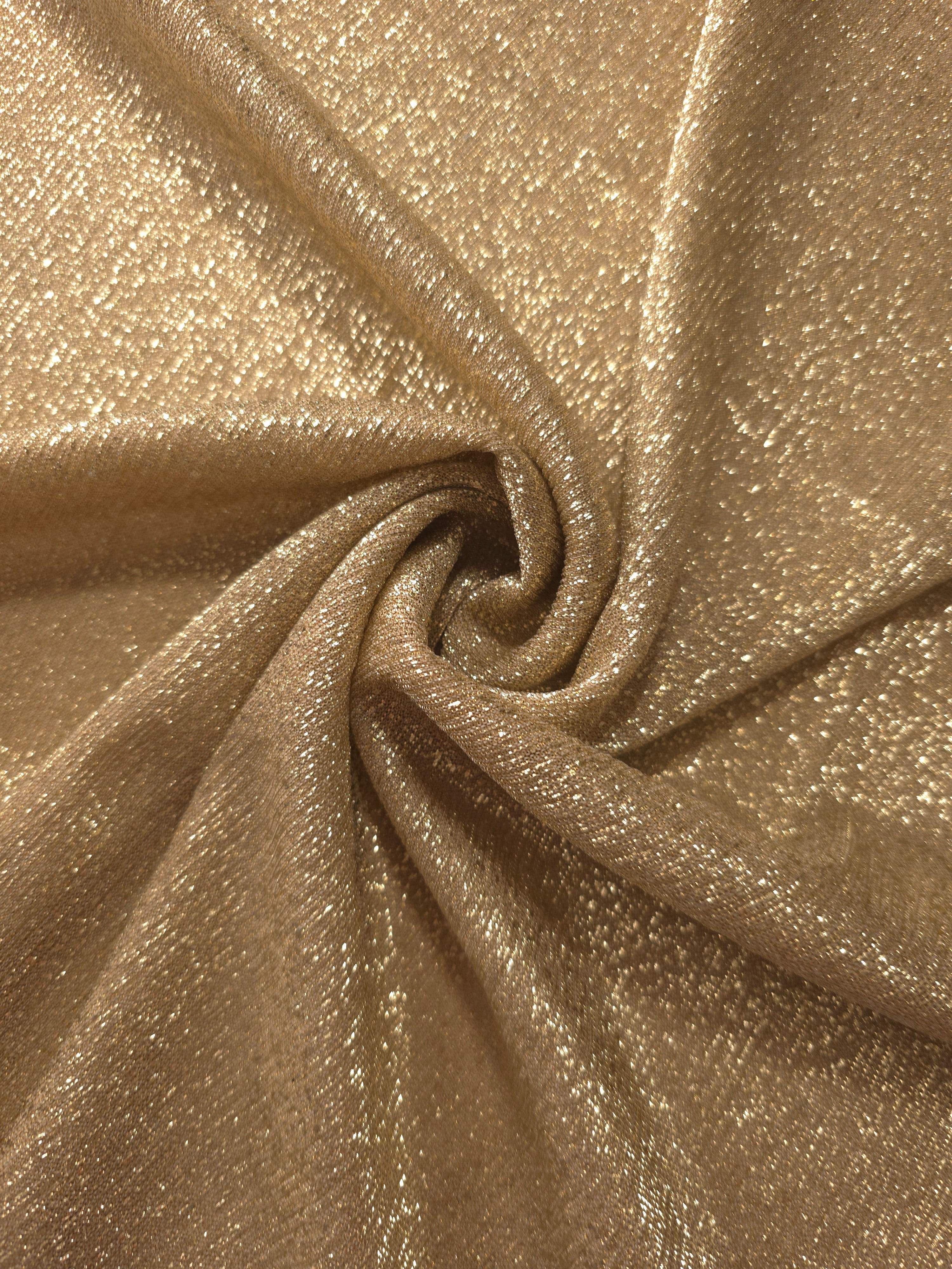 Swirl-draped Pale Gold Sheer Glitter Stretch Tulle Fabric capturing reflective sparkle and fluid movement through flexible folds