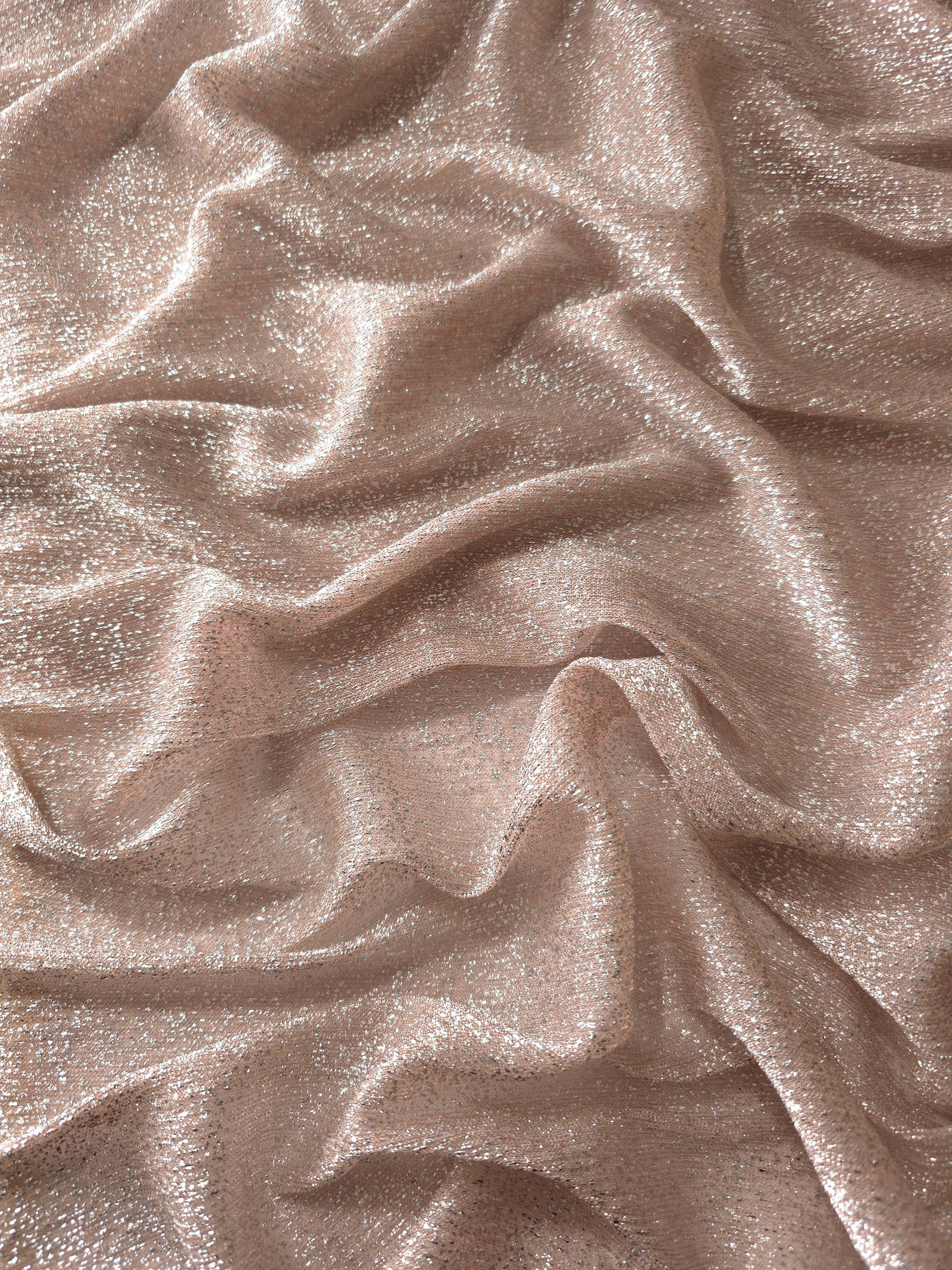 Draped Rose Taupe Sheer Glitter Stretch Tulle Fabric showing scattered sparkle across fluid folds for eveningwear and stage looks
