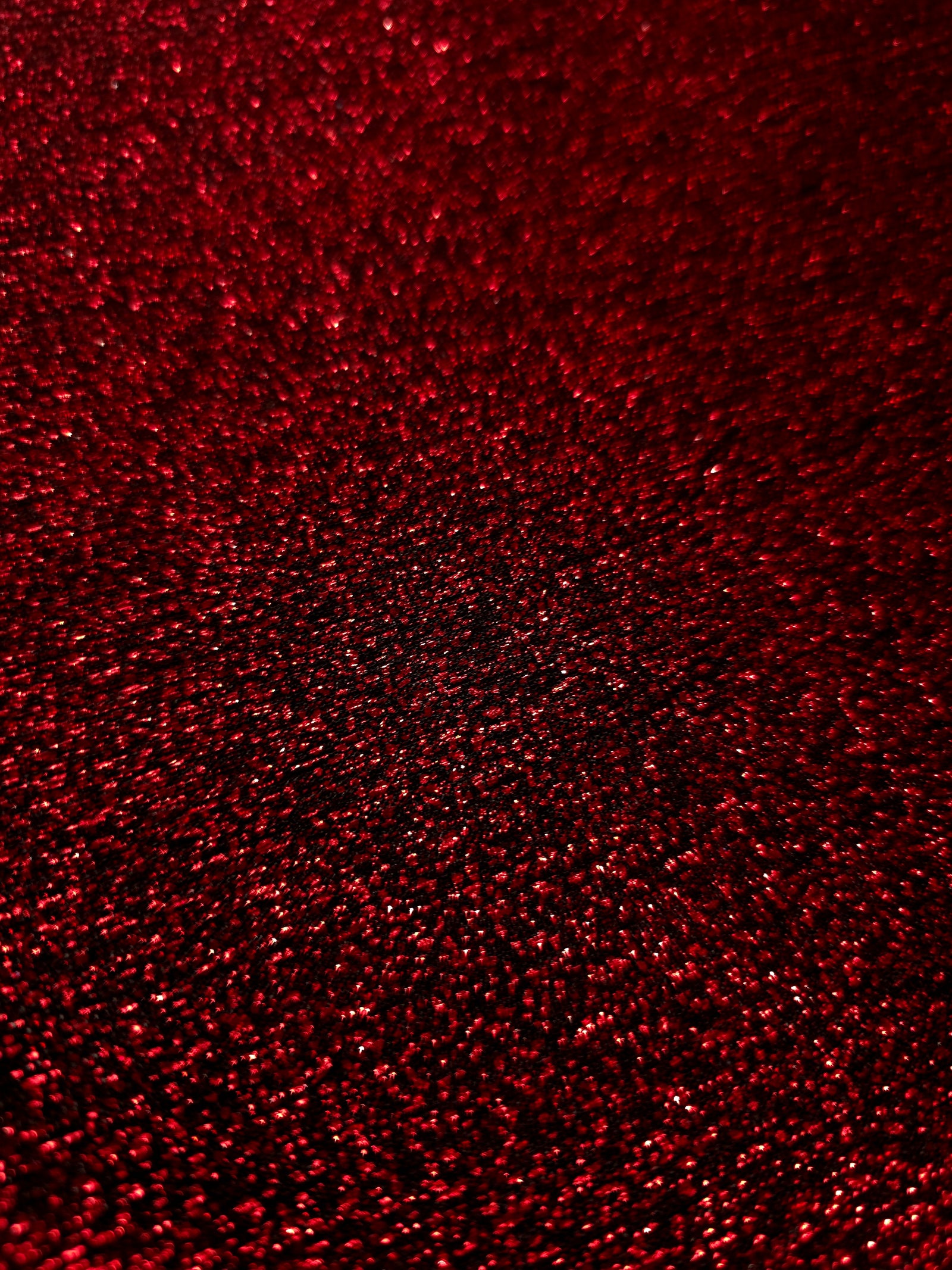 Close-up of Ruby Red Sheer Glitter Stretch Tulle Fabric highlighting all-over glitter, fine mesh texture and airy transparency