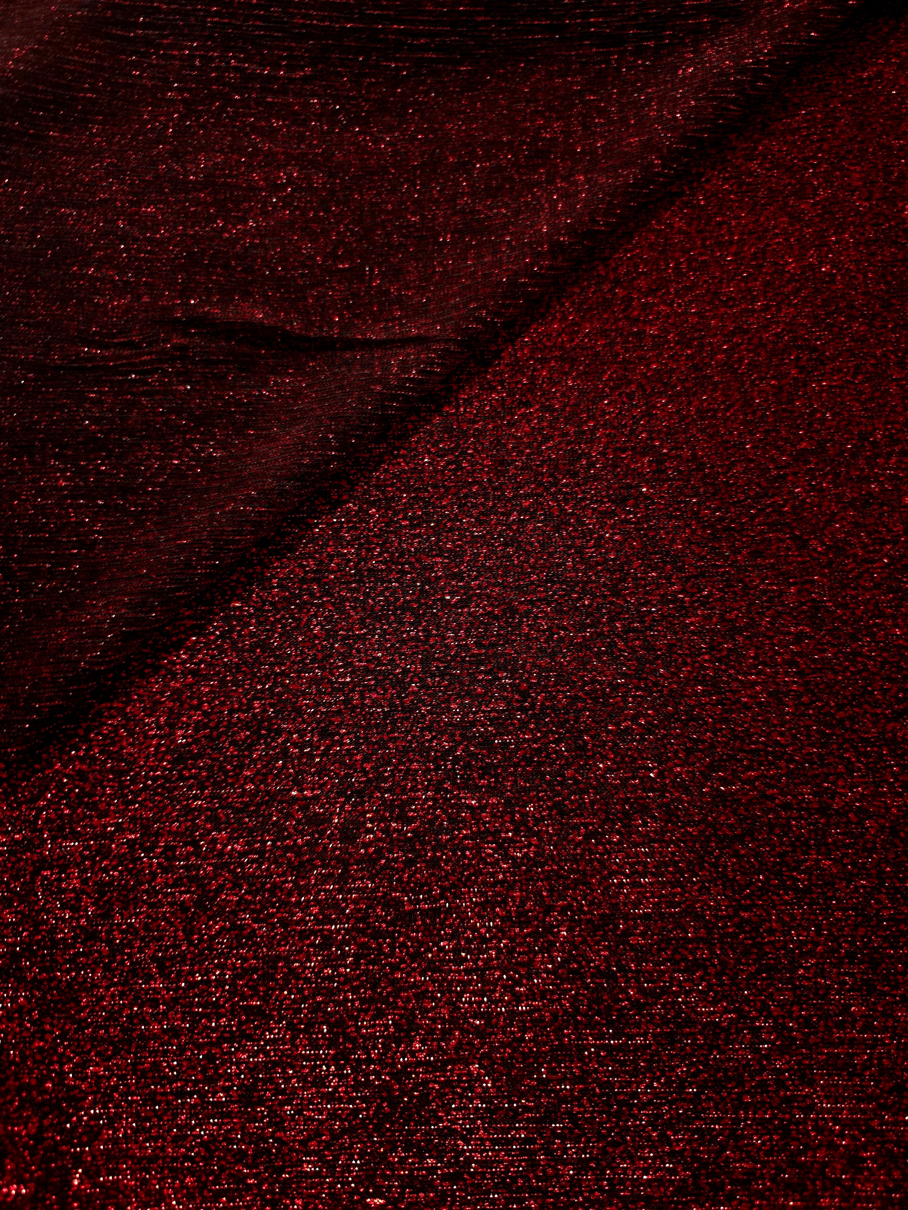 Front and back of Ruby Red Sheer Glitter Stretch Tulle Fabric showing transparent knit construction and flexible 4-way stretch