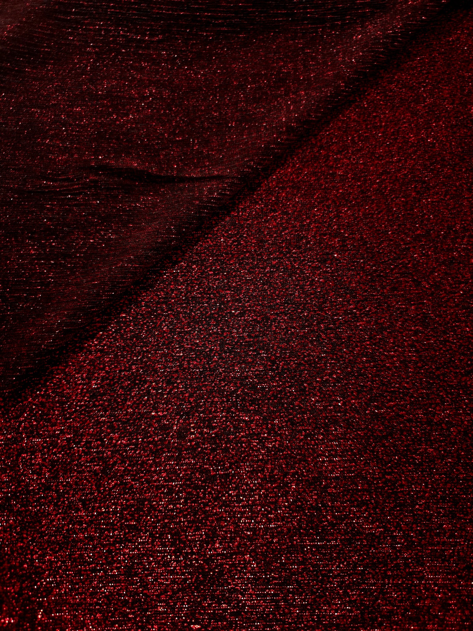 Front and back of Ruby Red Sheer Glitter Stretch Tulle Fabric showing transparent knit construction and flexible 4-way stretch