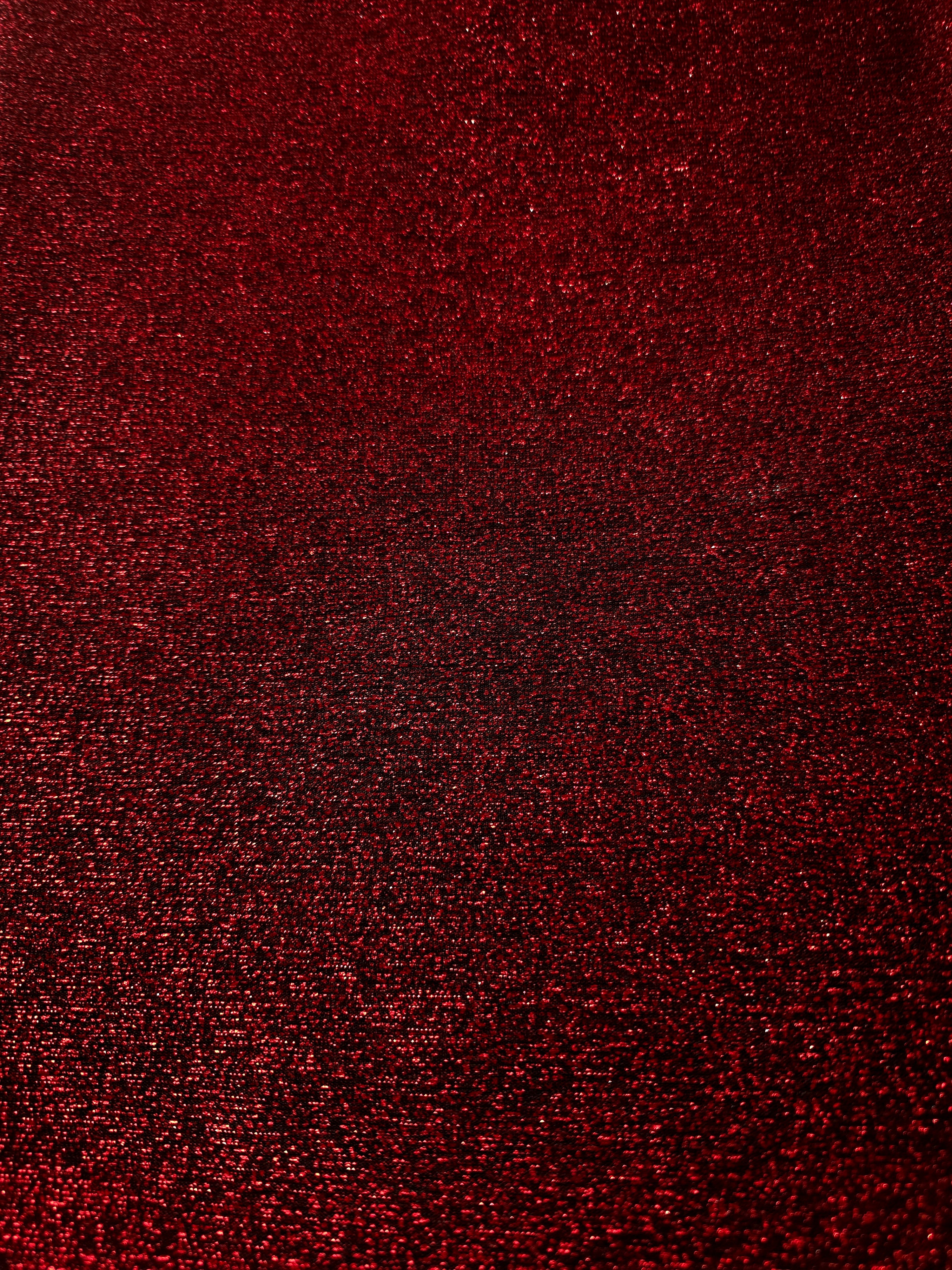 Surface detail of Ruby Red Sheer Glitter Stretch Tulle Fabric showing glitter coverage across the fine sheer tulle base