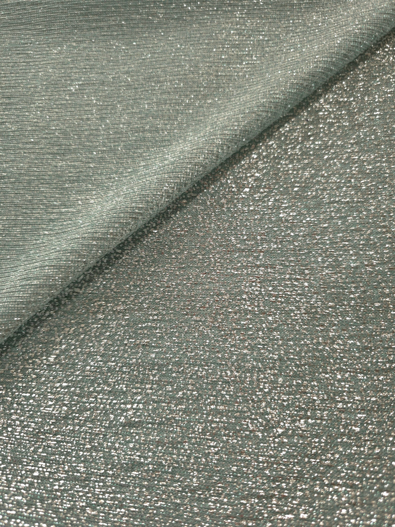 Front and back of Silver Sage Sheer Glitter Stretch Tulle Fabric showing transparent knit construction and flexible 4-way stretch