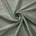 Swirl-draped Silver Sage Sheer Glitter Stretch Tulle Fabric capturing reflective sparkle and fluid movement through flexible folds