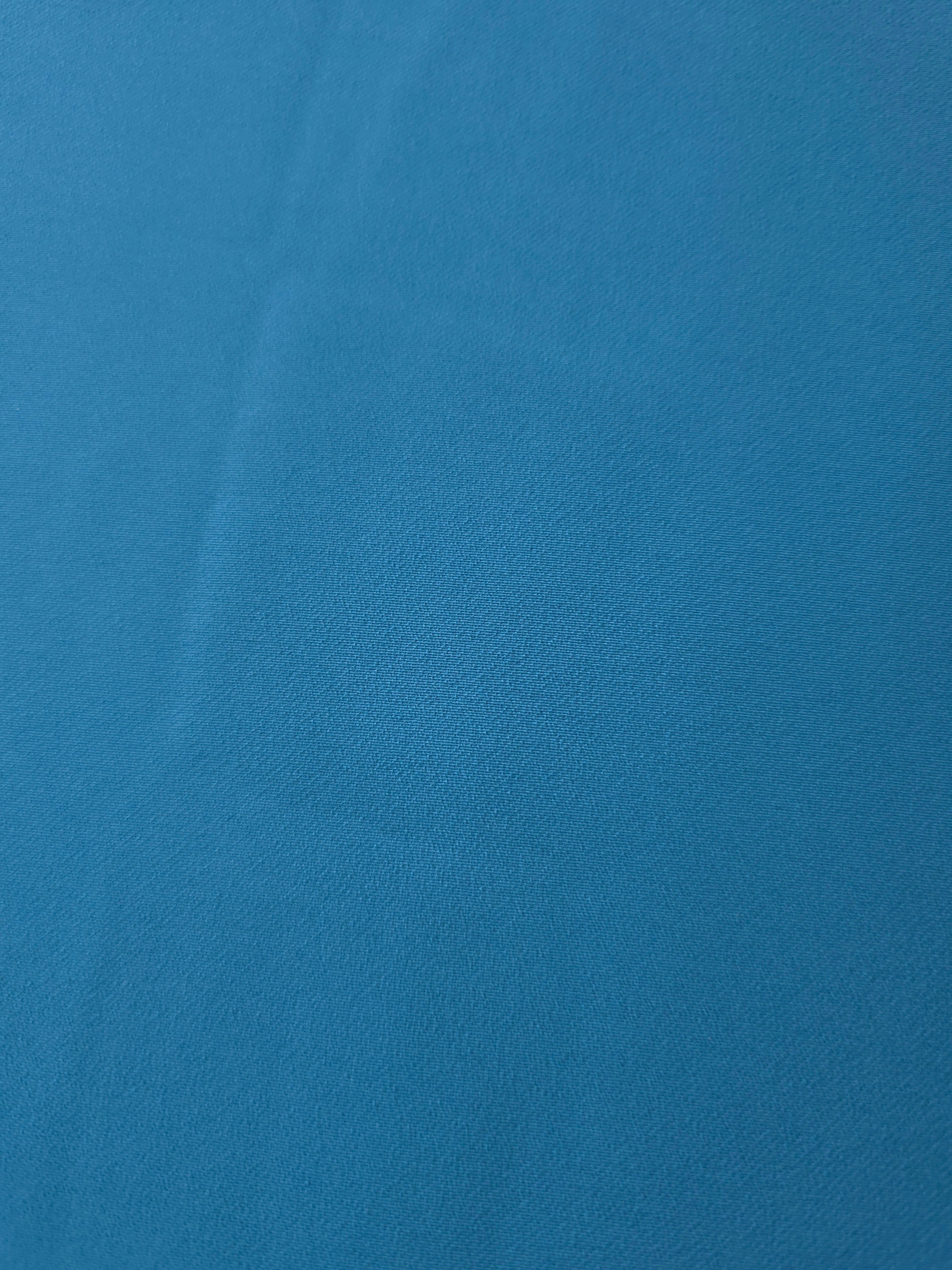 Fine close-up of Steel Blue mechanical polyester crepe showing smooth woven texture and a silky-soft hand