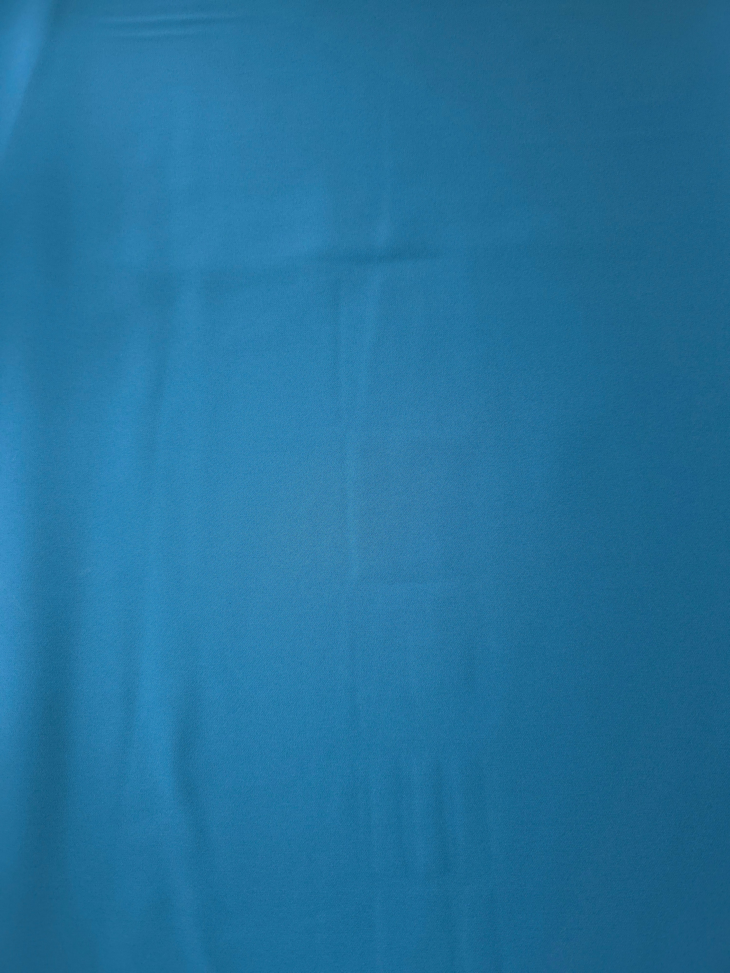 Steel Blue Italian polyester crepe shown flat, smooth apparel fabric with a soft silky-feel finish