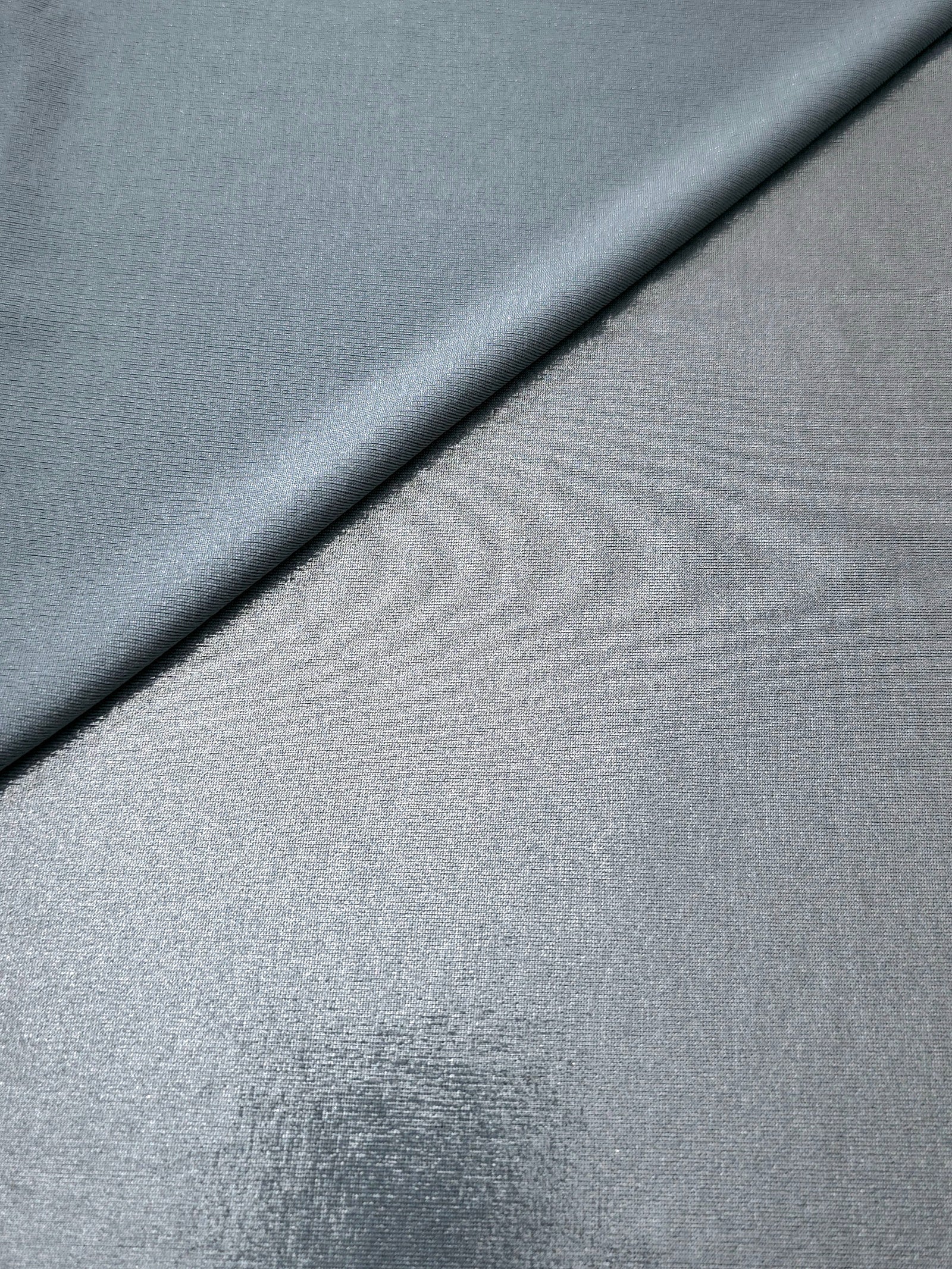 Softly folded Steel Gray foiled spandex showing metallic shine and flexible hand for costumes, eveningwear and creative sewing