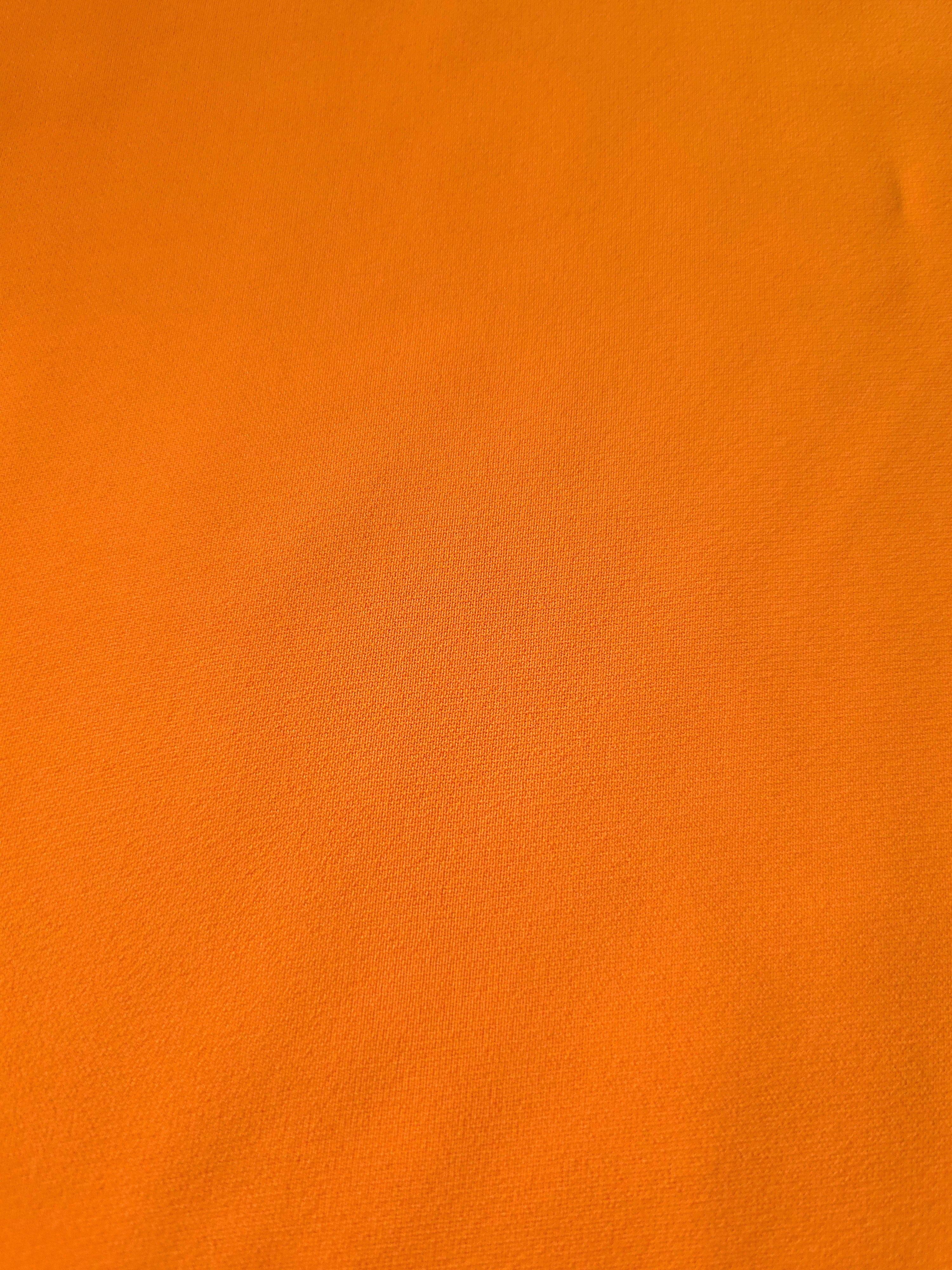 Fine texture close-up of Tangerine Orange mechanical polyester crepe showing a smooth silky-soft woven hand