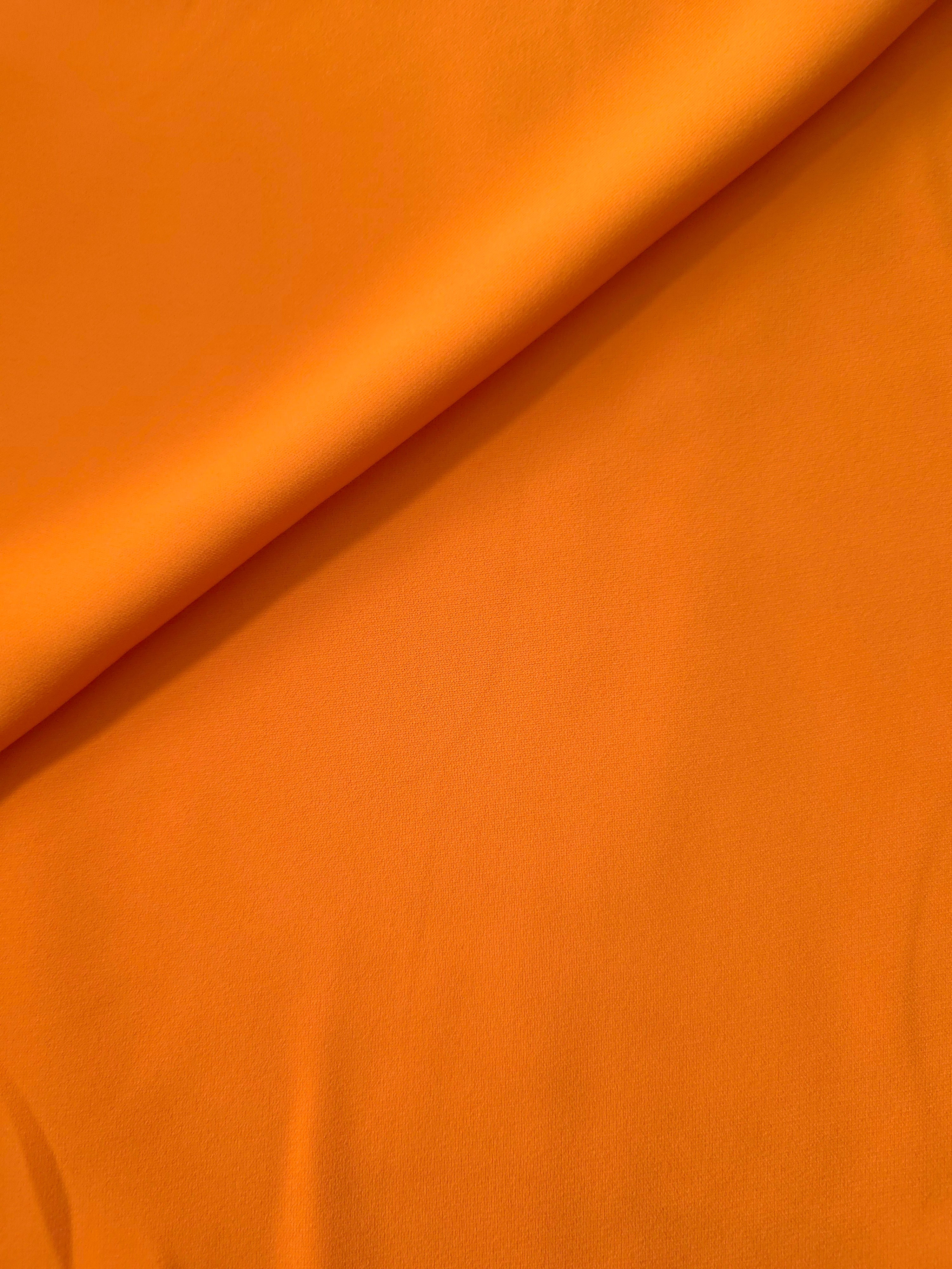 Soft-fold view of Tangerine Orange polyester crepe showing fluid drape for dresses, skirts and blouse making