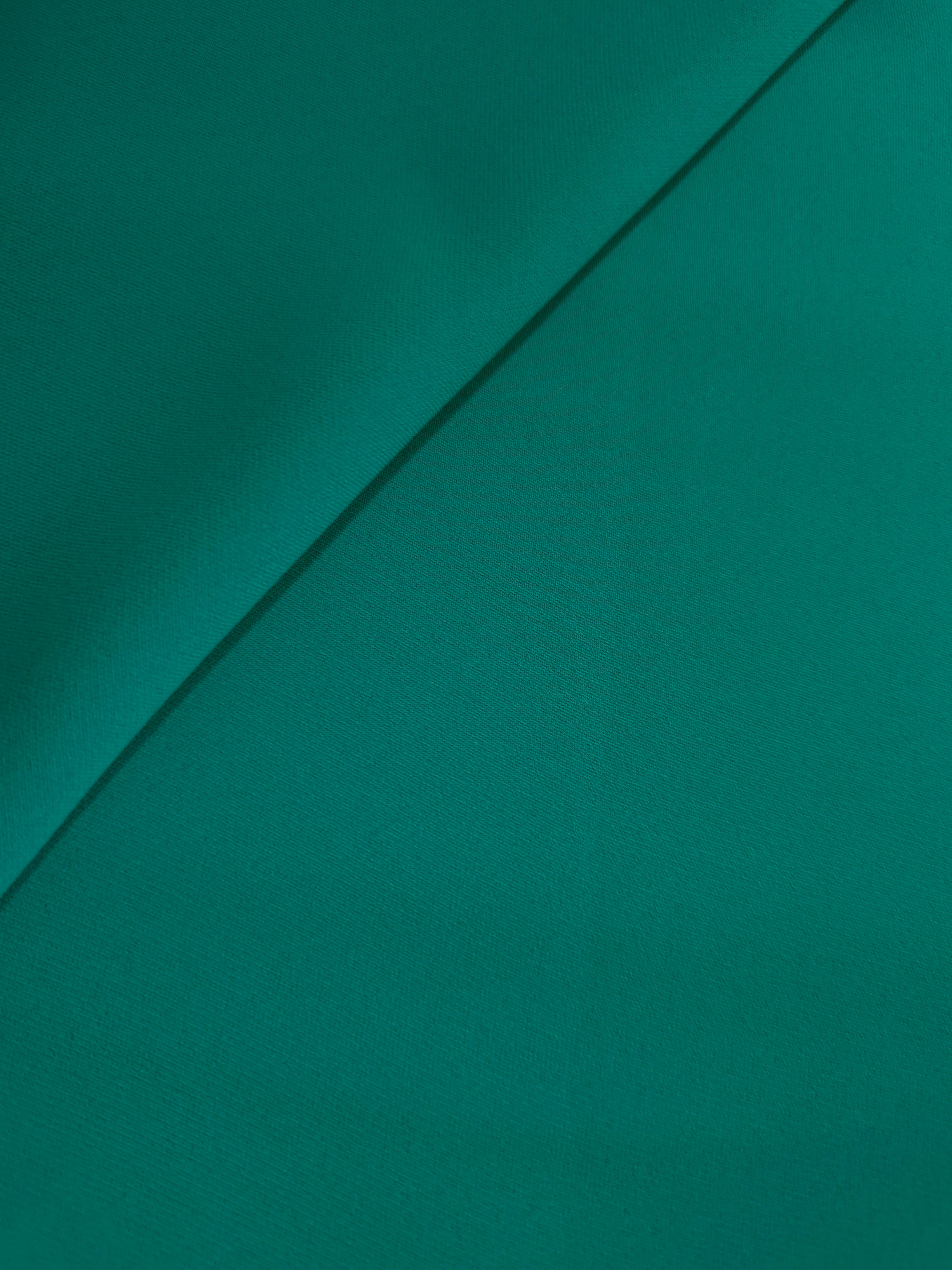 Loose fold of Teal Green polyester crepe showing fluid drape for dresses, skirts and soft tailoring