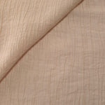 Flat view of Soft Beige Tencel jacquard with fine root line texture for dresses and layers.