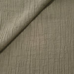 Folded Sage Green Tencel jacquard with fine root line texture for blouse and skirt layers.