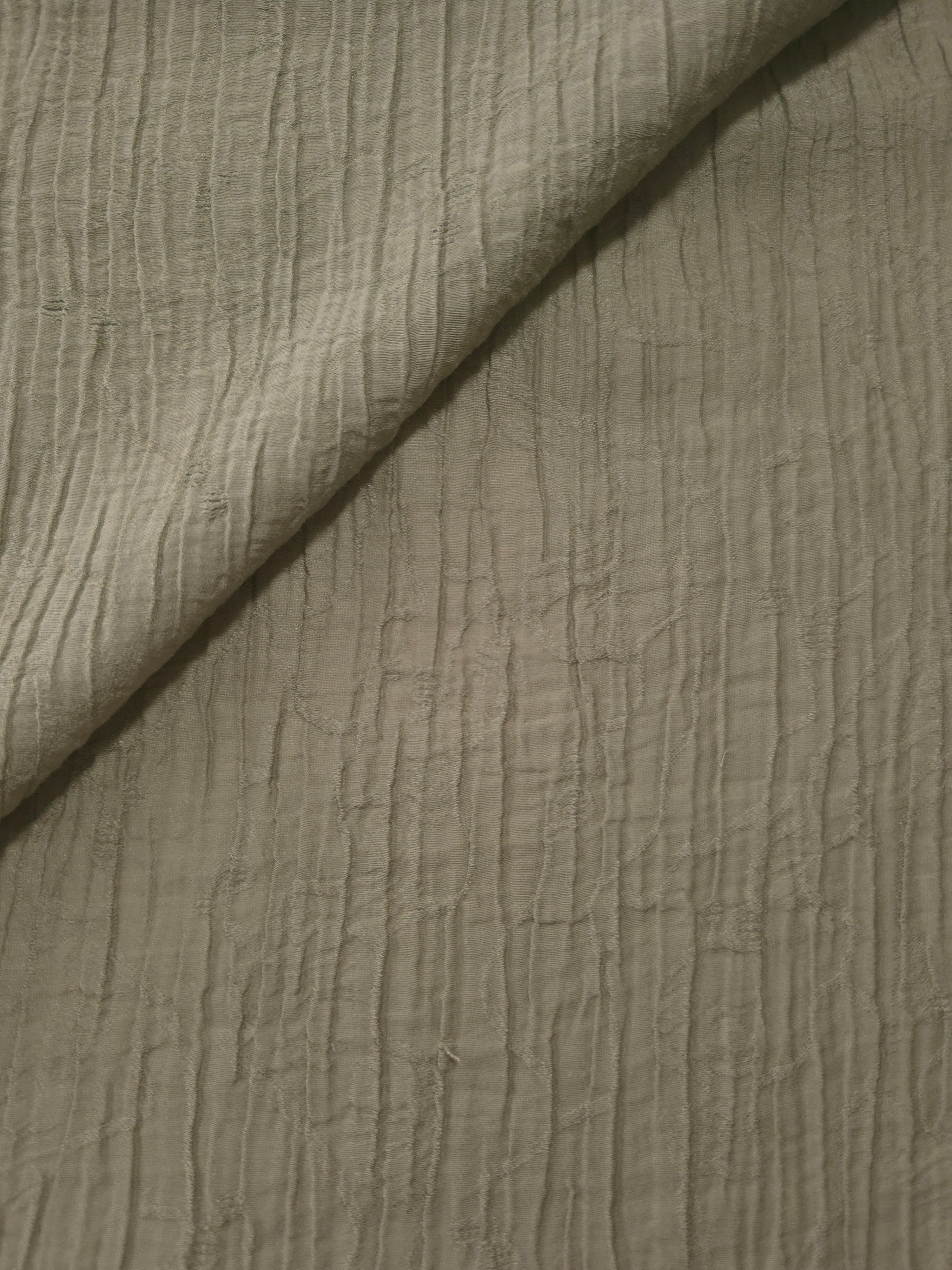 Folded Sage Green Tencel jacquard with fine root line texture for blouse and skirt layers.