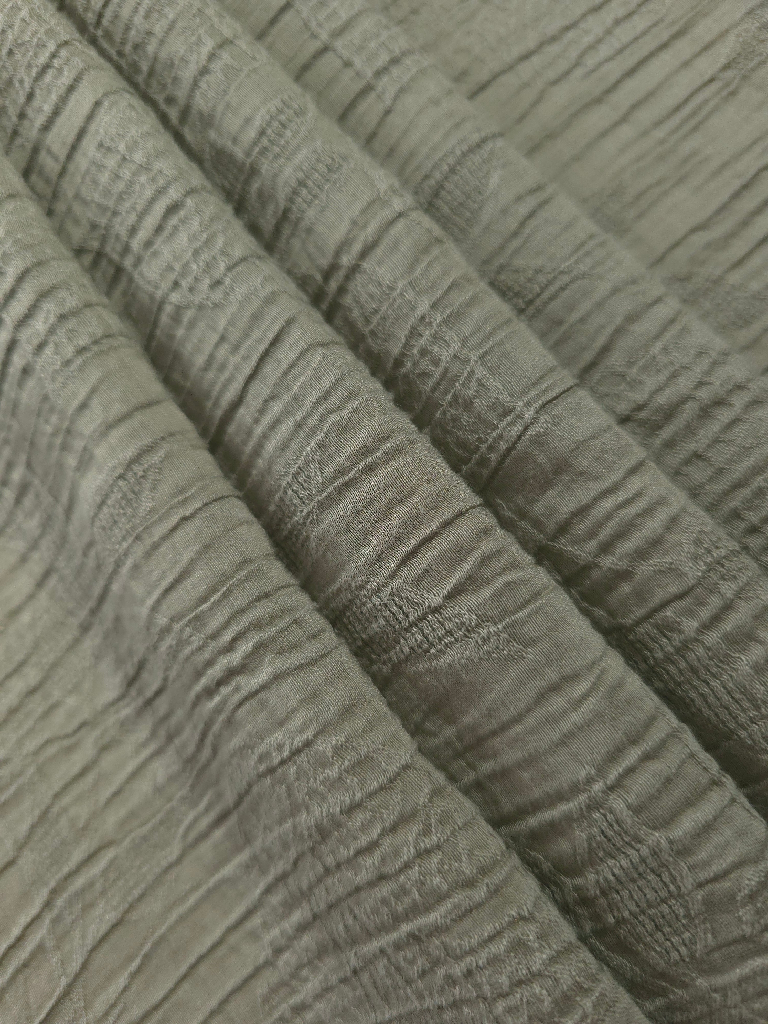 Folded Sage Green Tencel jacquard with tonal leaf texture for blouse and skirt layers.