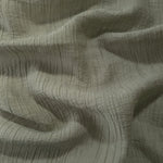 Fold detail of Sage Green Tencel jacquard with tonal leaf texture for dressmaking.