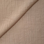 Folded Soft Beige Tencel jacquard with tonal swirl texture for blouse and skirt layers.