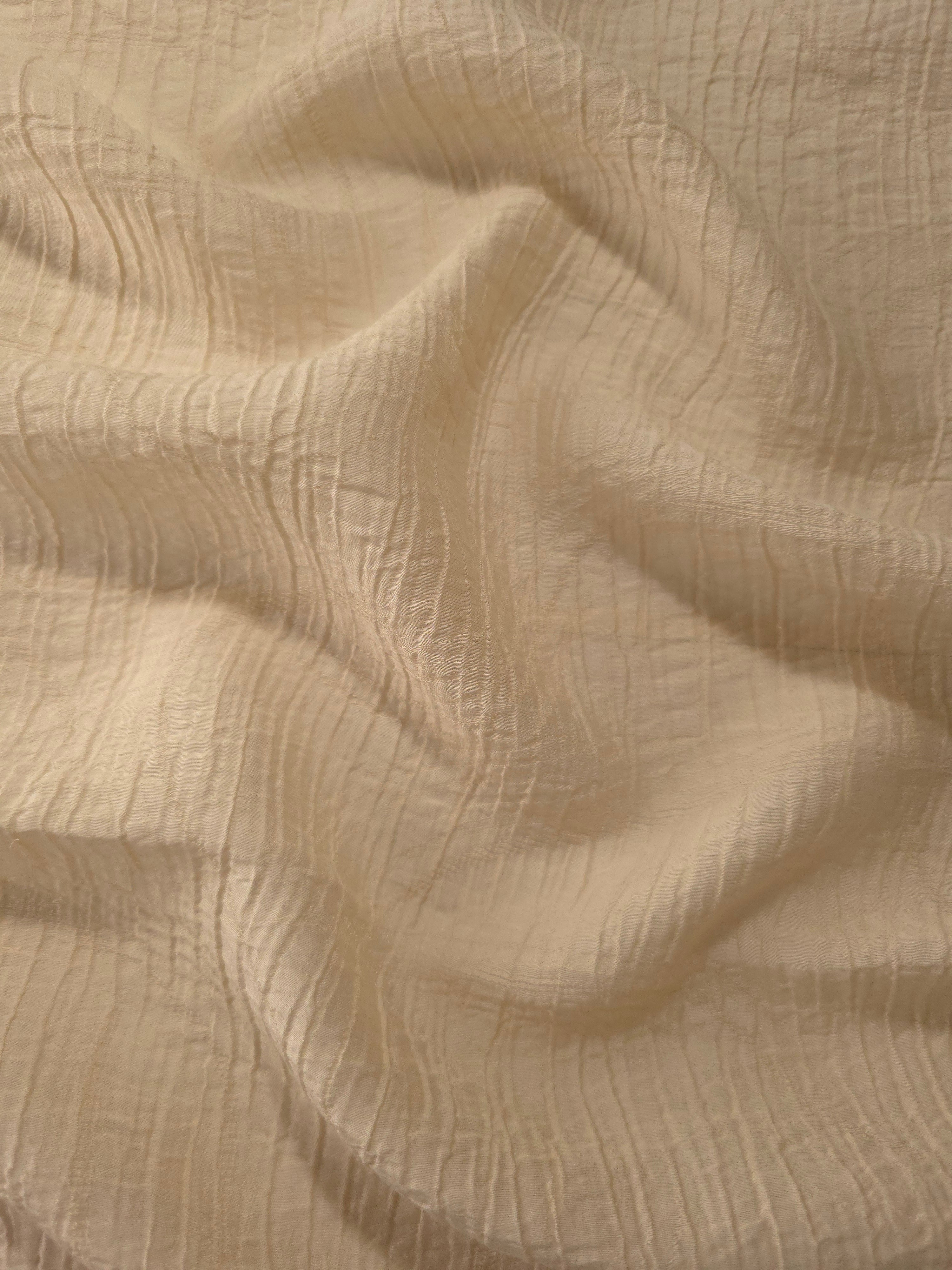 Fold detail of Butter Yellow Tencel jacquard with tonal swirl texture for dressmaking.