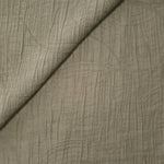 Folded Sage Green Tencel jacquard with tonal swirl texture for blouse and skirt layers.
