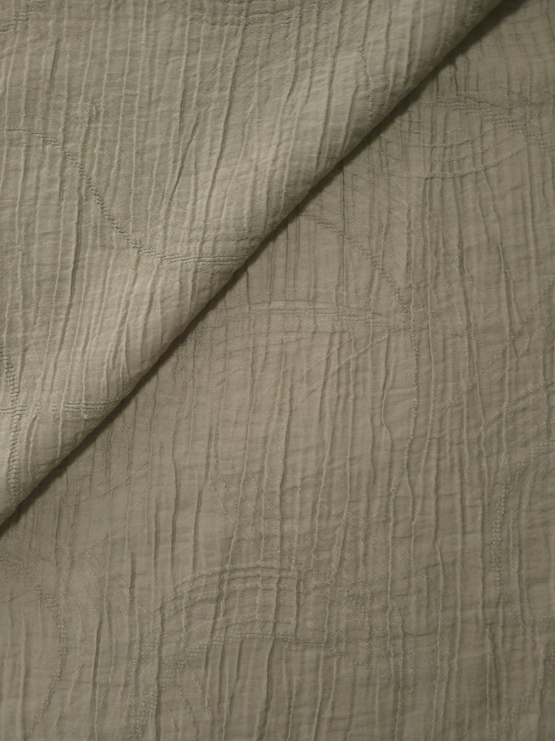 Folded Sage Green Tencel jacquard with tonal swirl texture for blouse and skirt layers.