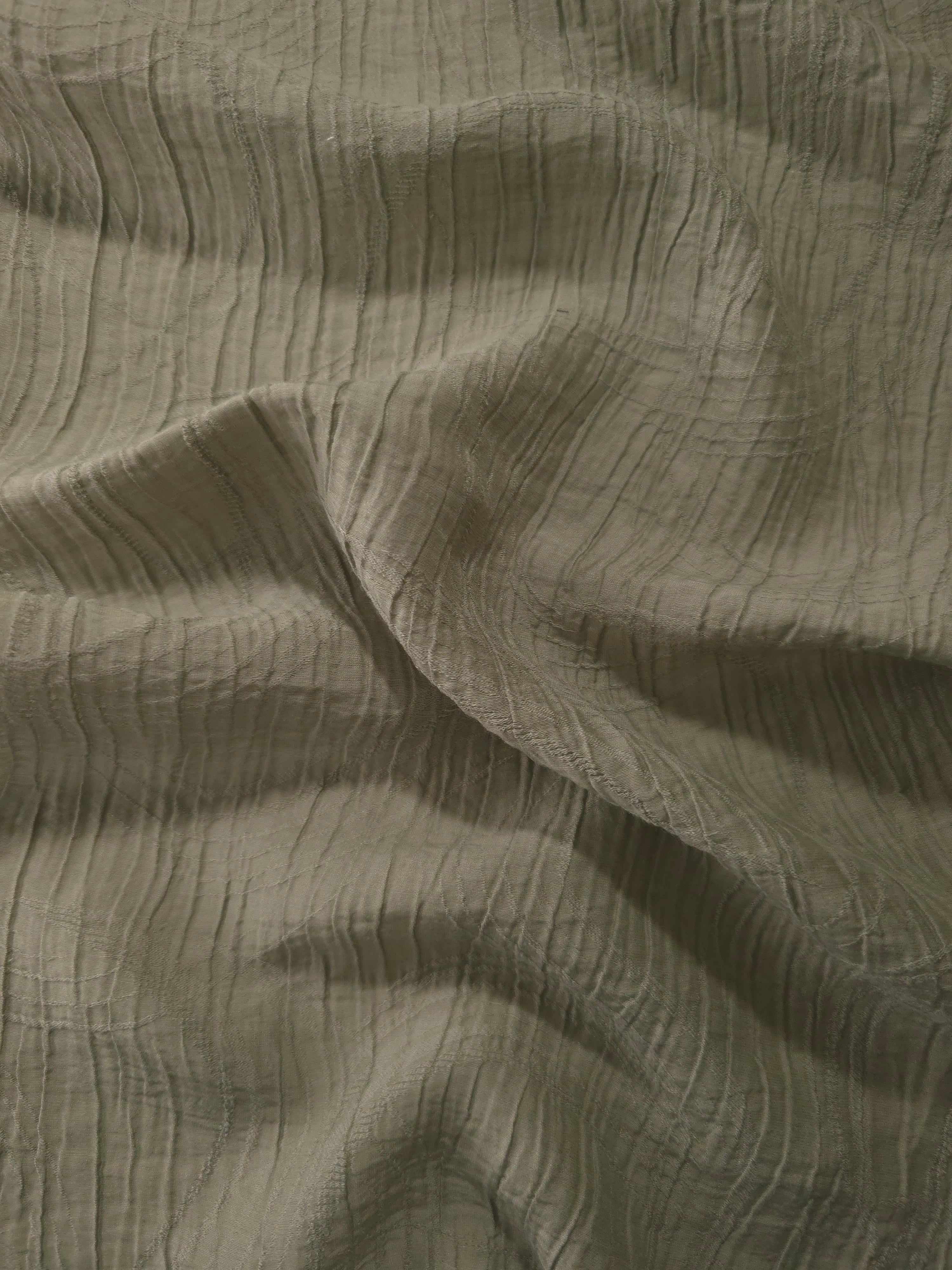 Detail view of Sage Green Tencel jacquard with tonal swirl texture for soft layers.