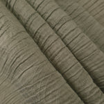 Fold detail of Sage Green Tencel jacquard with tonal swirl texture for dressmaking.