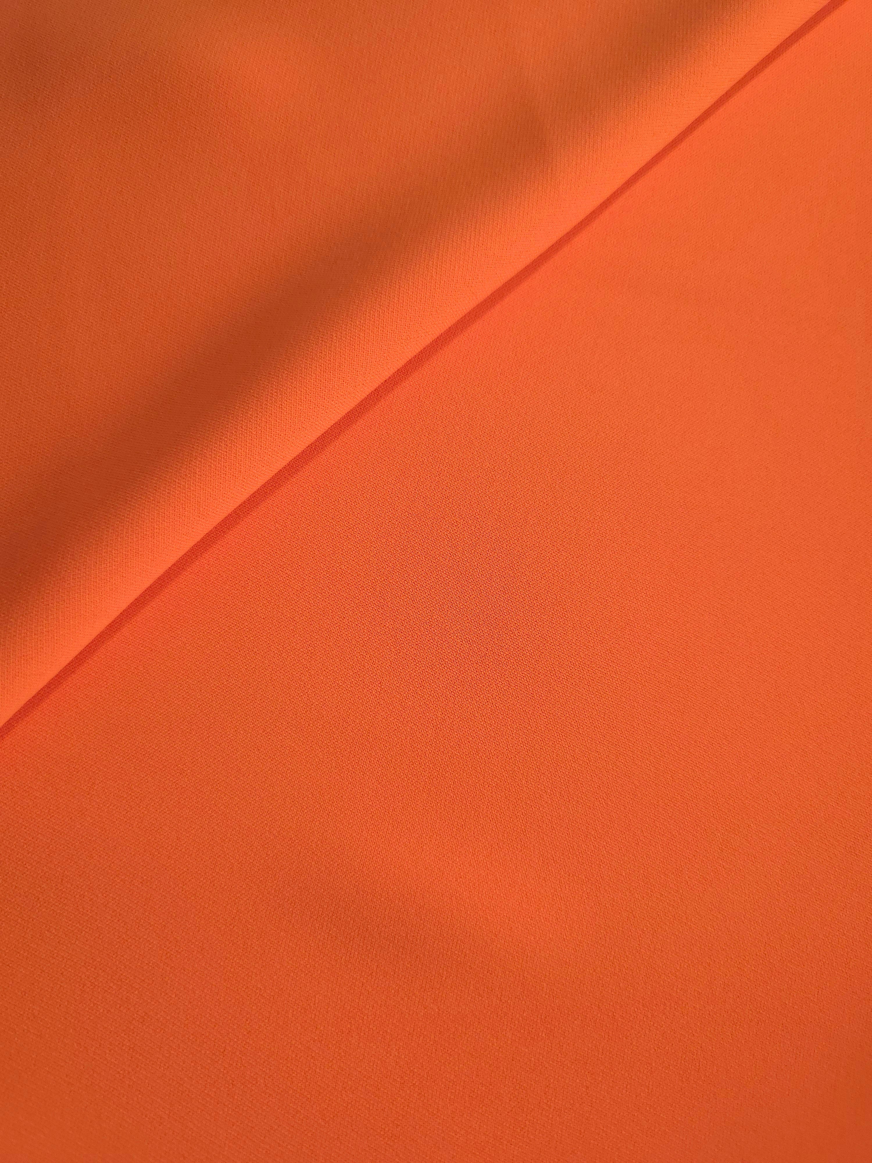 Terracotta Orange polyester crepe in a soft fold, showing flowing drape for garment making and dressmaking