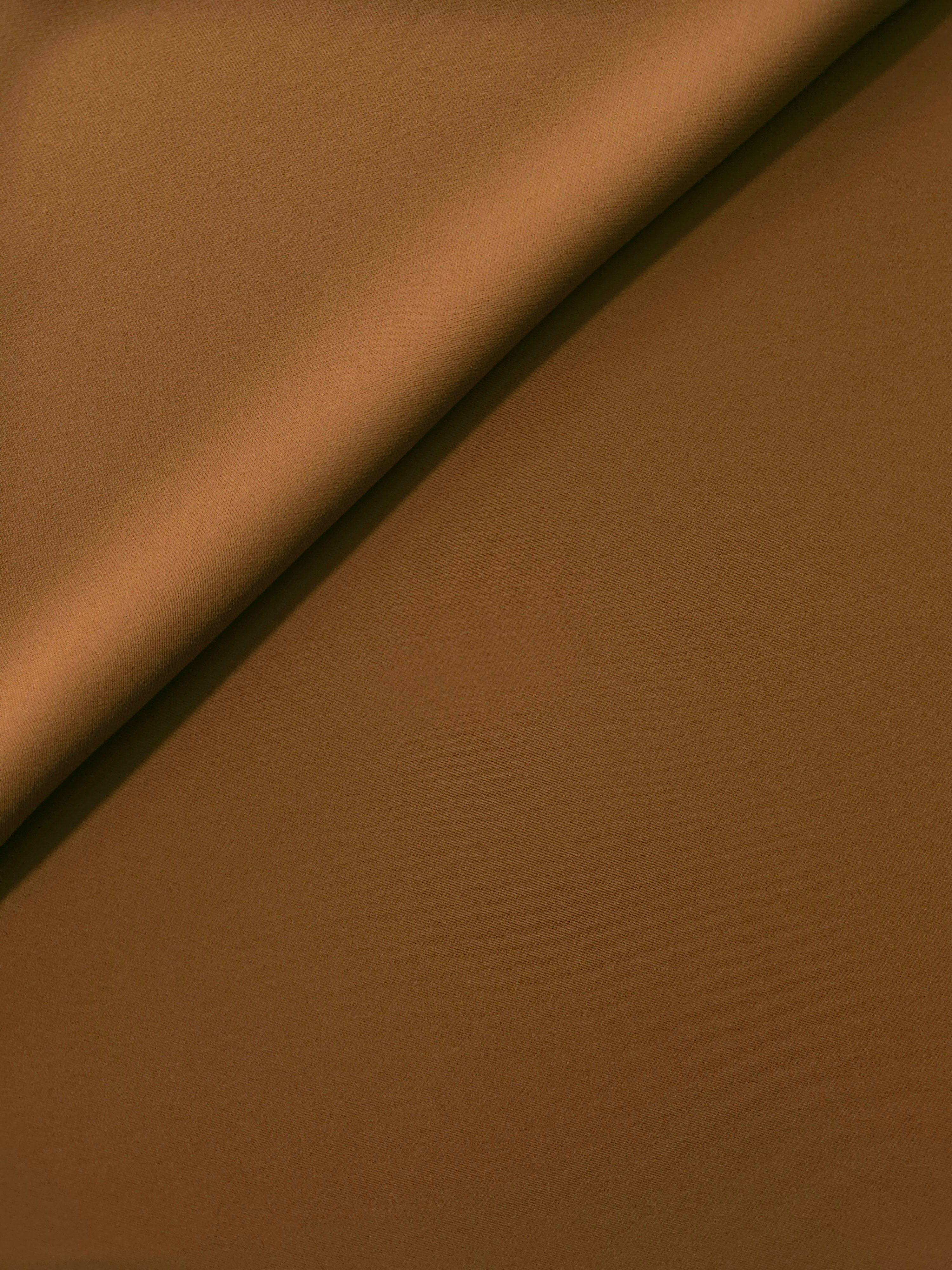 Toffee Brown Korean polyester crepe in a soft fold, showing fluid drape for blouses and flowing dresses