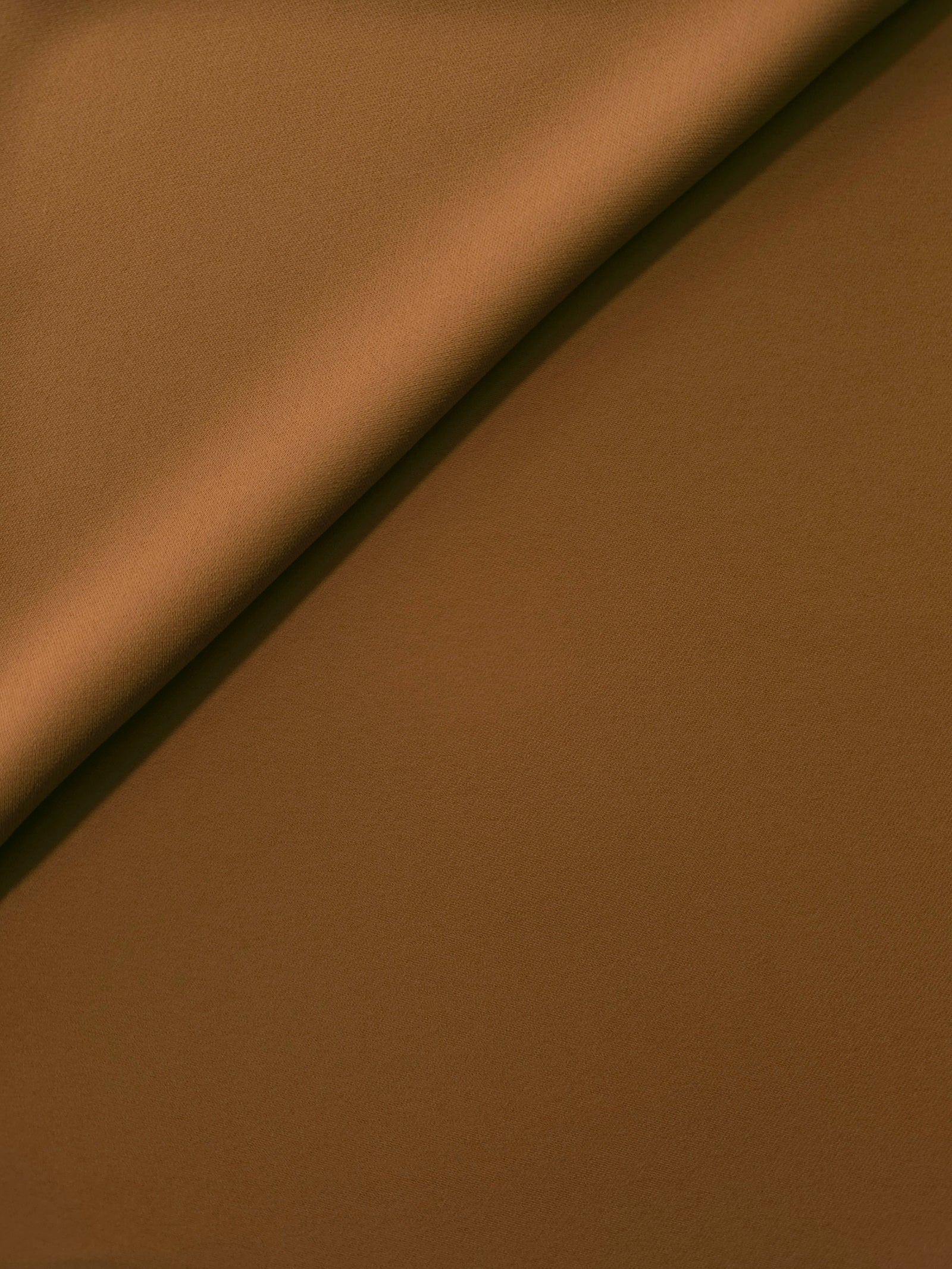 Toffee Brown Korean polyester crepe in a soft fold, showing fluid drape for blouses and flowing dresses