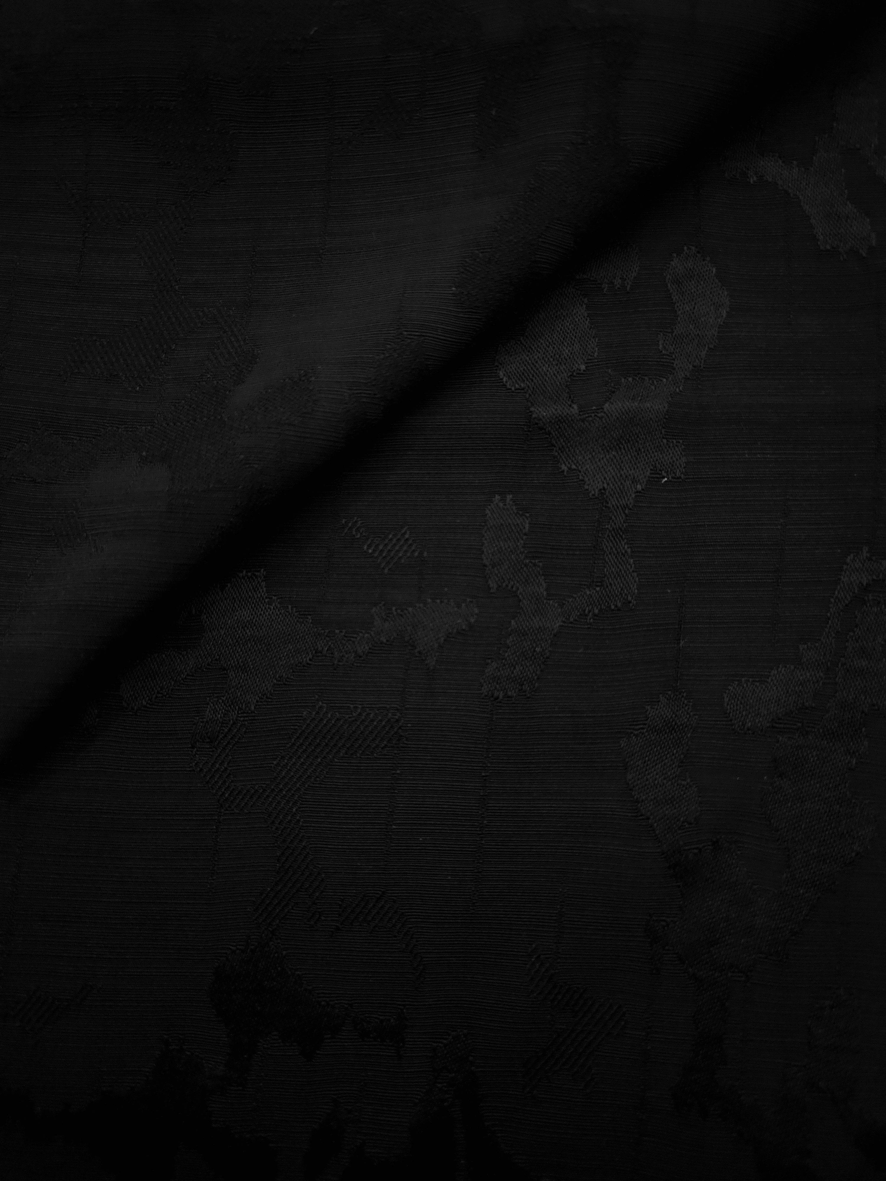 Jet black botanical rayon jacquard presented in a diagonal fold to display its fall for tunics, kaftans and relaxed tailoring.